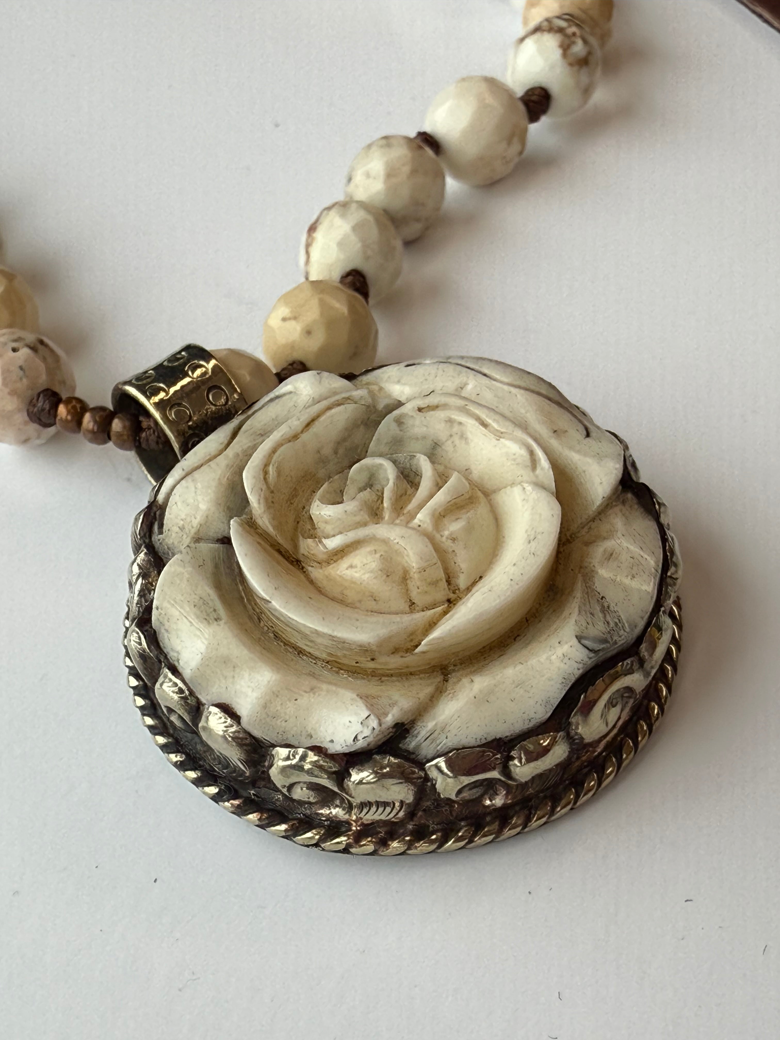 Necklace with a detailed rose pendant on a white background