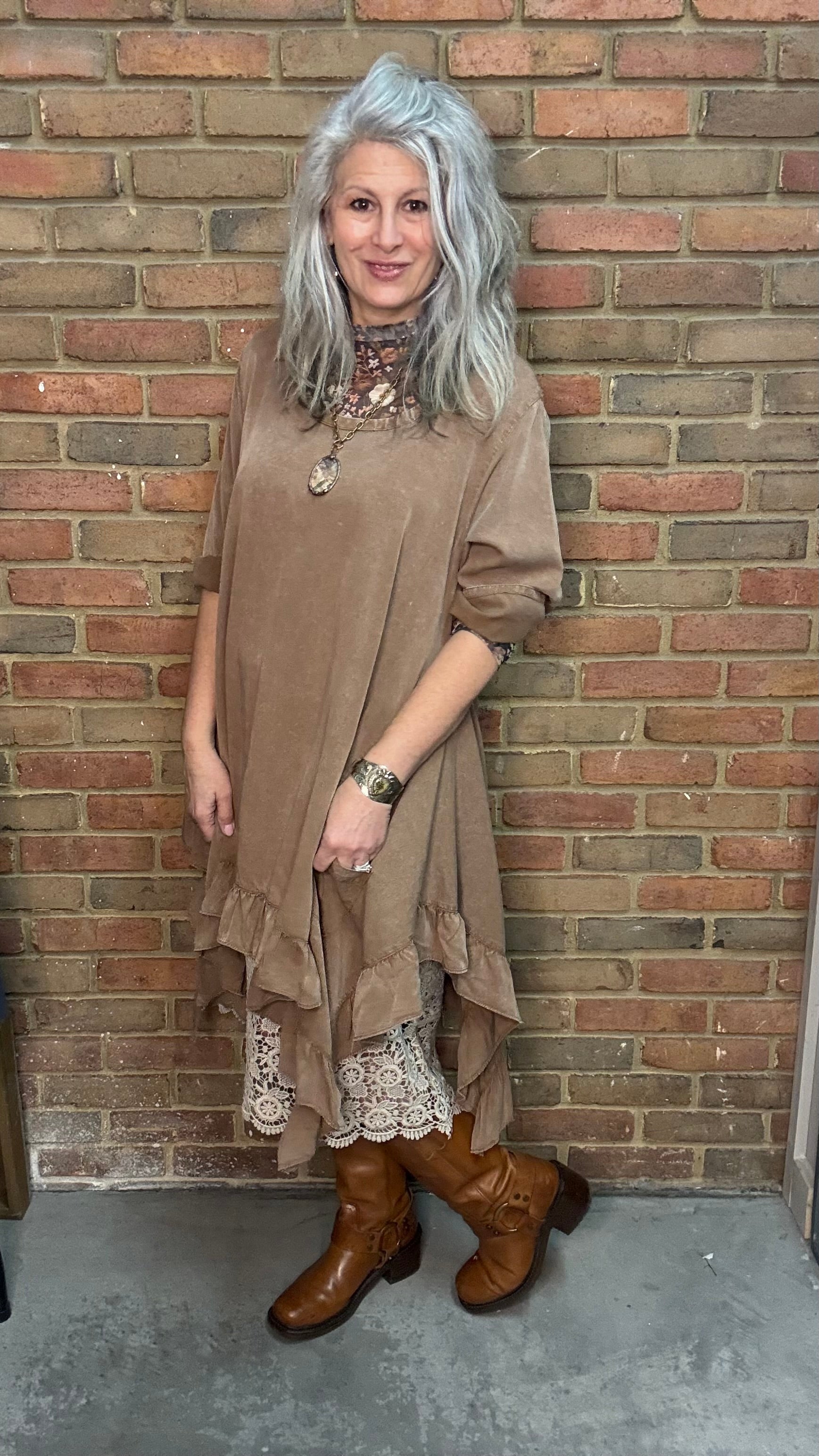 Woman wearing Tan Round Neck Ruffle Top/dress with a mesh top, slip, and Frye Boots.