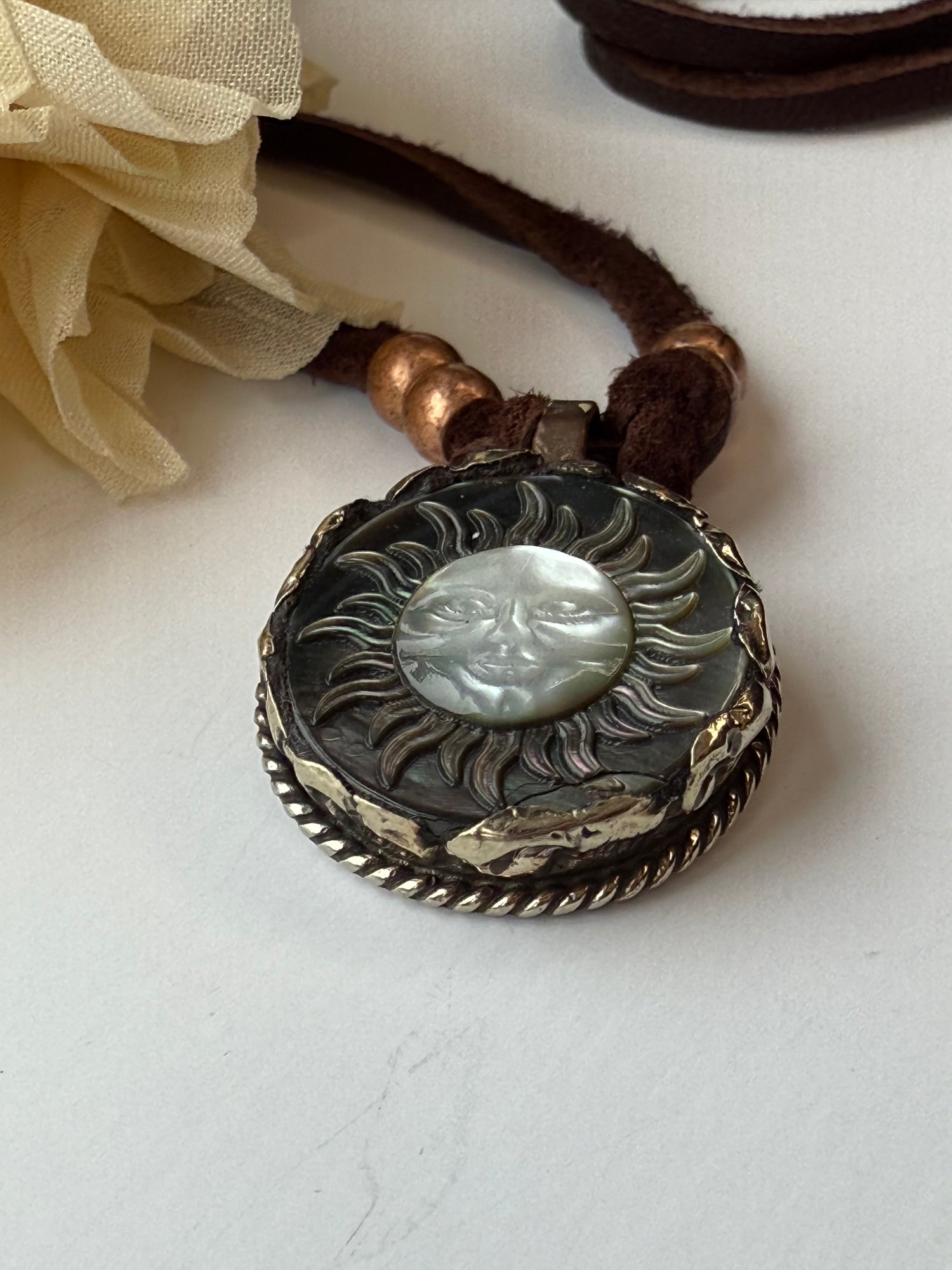 Decorative pendant with sun design on a white background