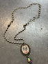 Necklace with a vintage-style pendant on a textured gray surface