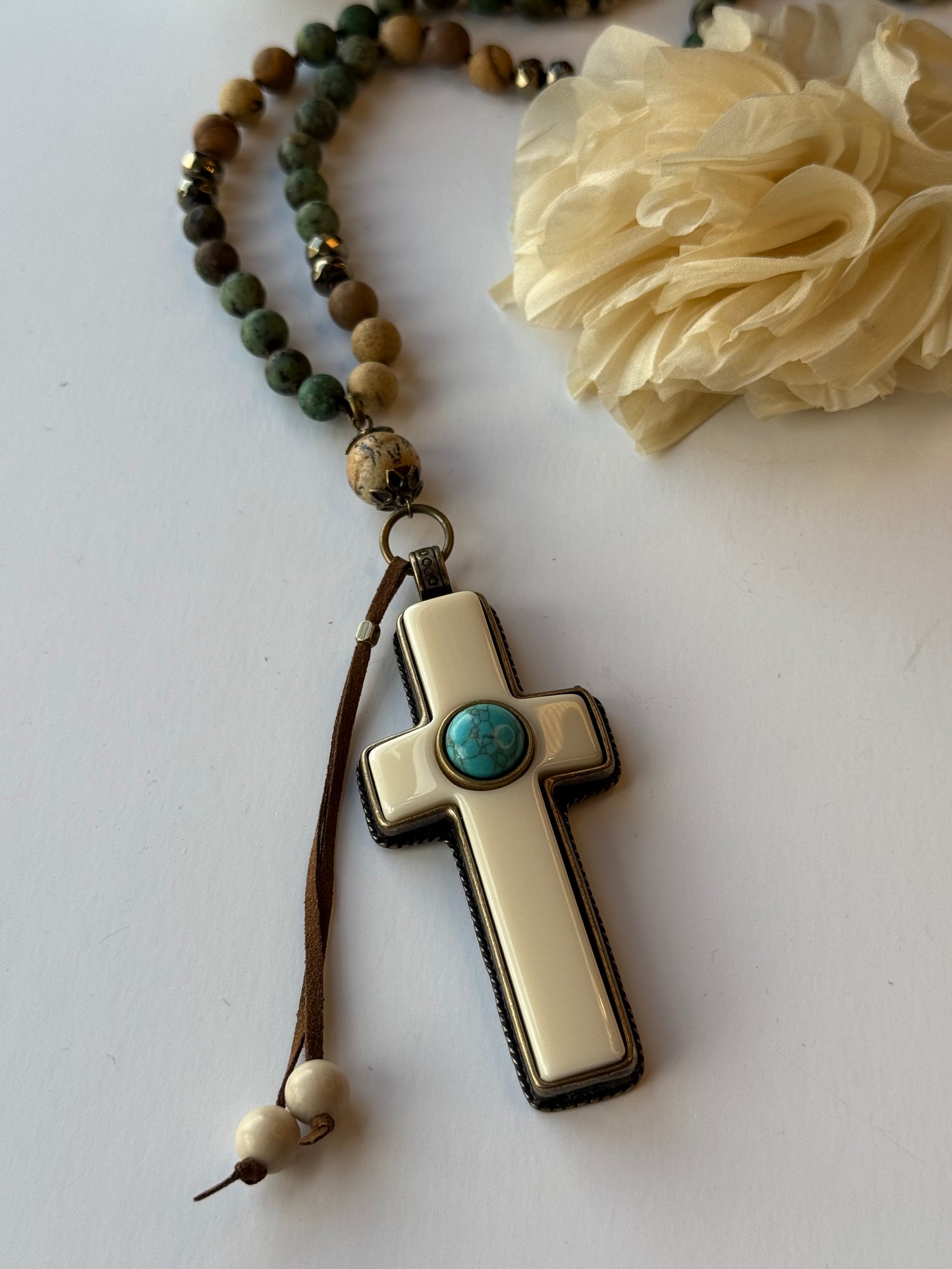 Necklace with cross pendant and beaded chain on a white background
