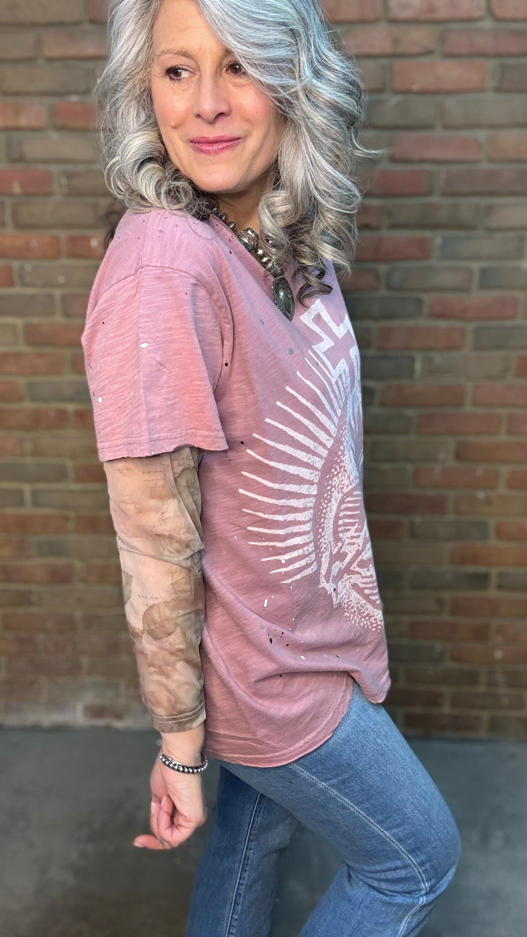Woman wearing Moon Dance Tee - Cherished Heart tee against brick wall.