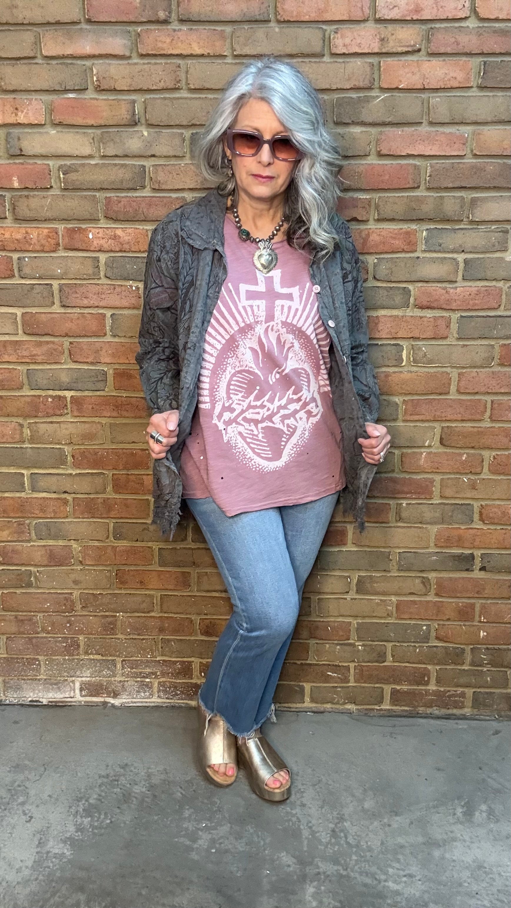Woman wearing Moon Dance Tee - Cherished Heart tee against brick wall.