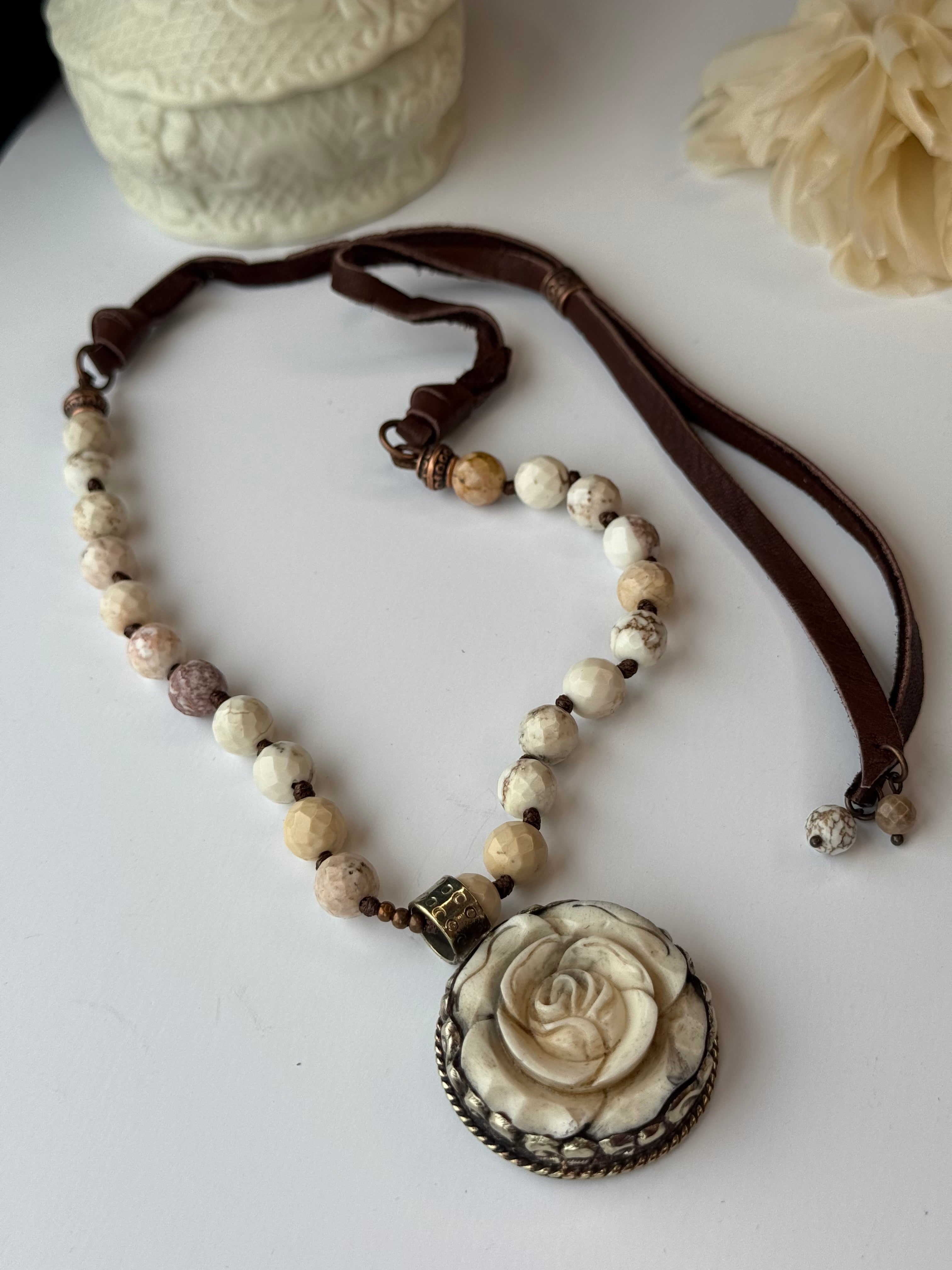 Necklace with rose-shaped pendant on a white surface