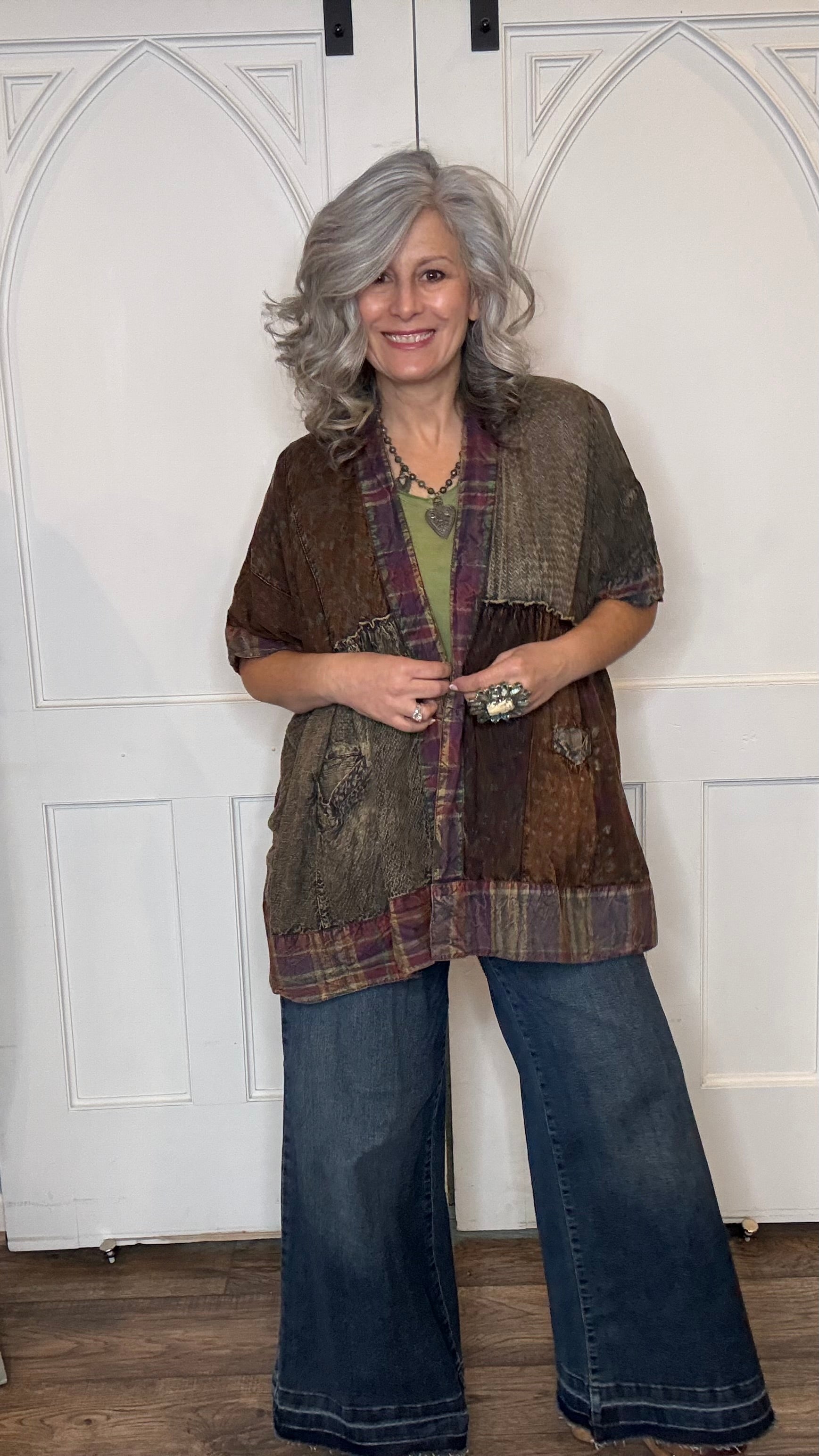 Woman wearing Boho Kimono Shrug Cardigan over a Moon Dance V-Neck in Olive and Judy Blue Palazzo Patch Pocket jeans in front of a white door.