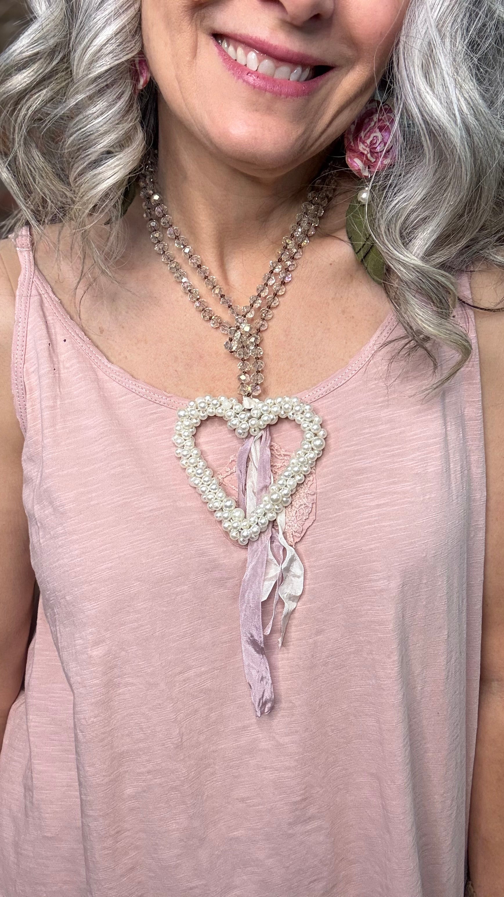 Woman wearing a Pearl Heart necklace with pink top.