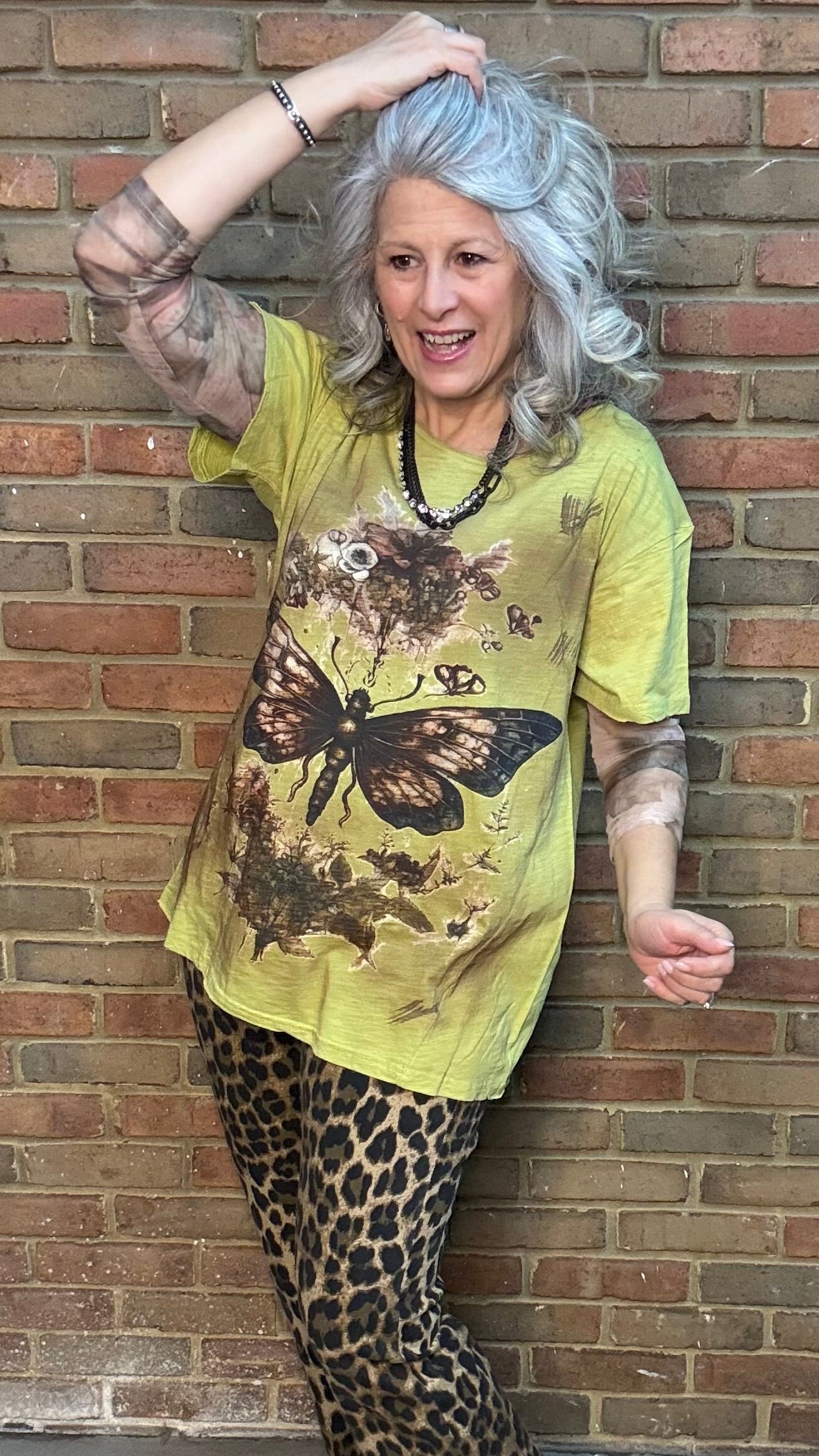 Woman wearing Moon Dance Tee - Evening Stop in front of a brick wall.