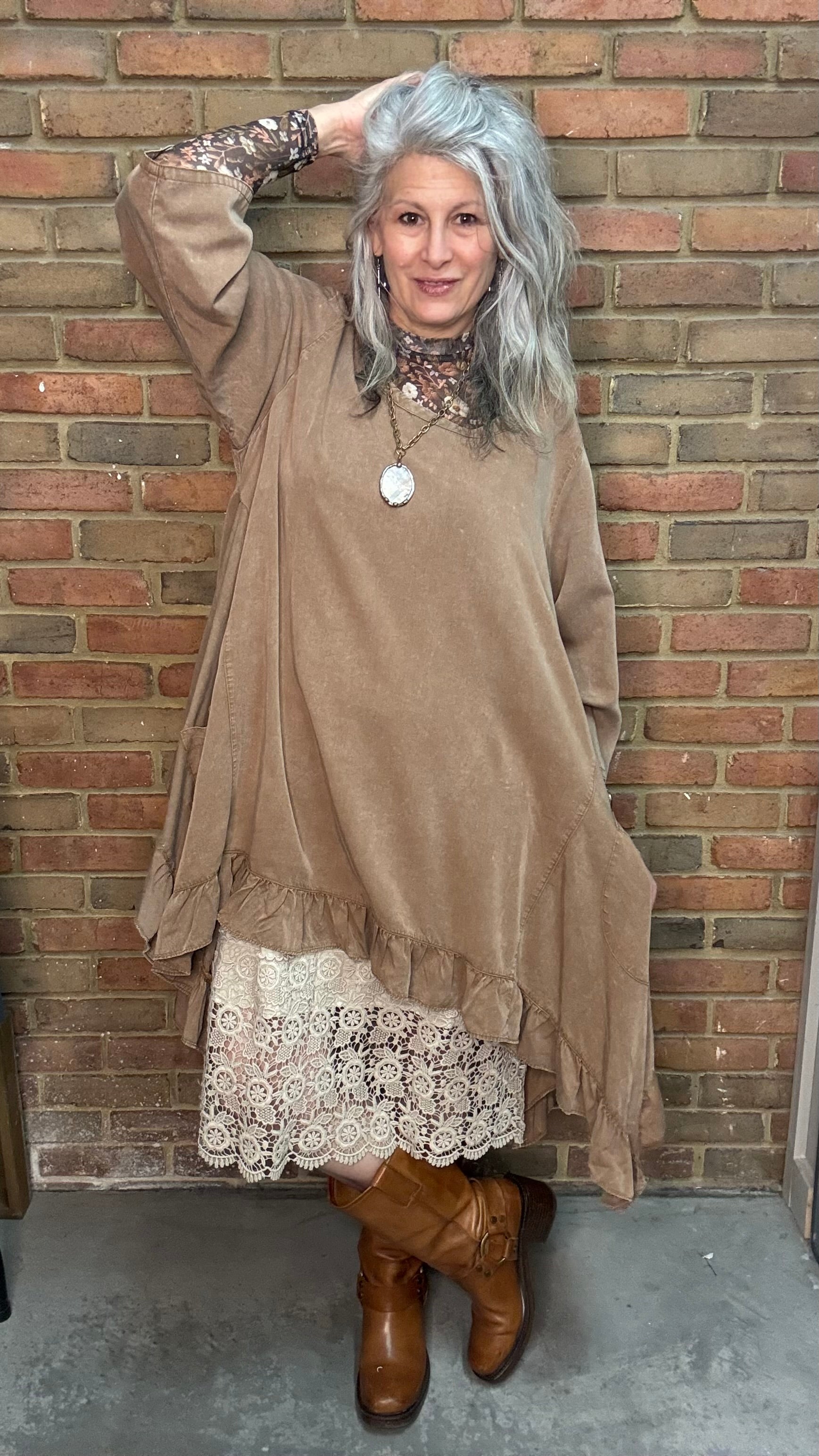 Woman wearing Tan Round Neck Ruffle Top/dress with a mesh top, slip, and Frye Boots.