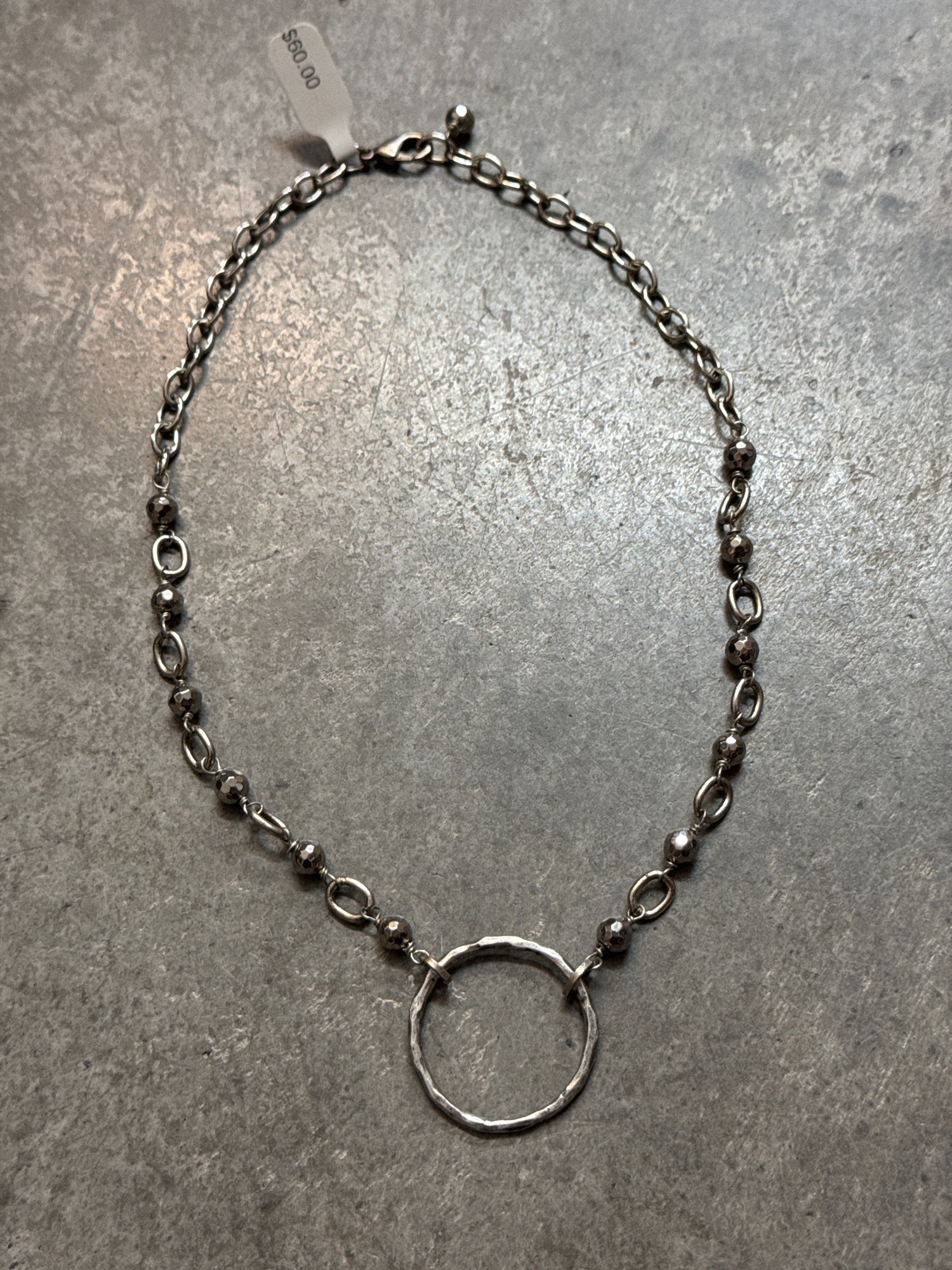 Silver chain necklace on a gray surface