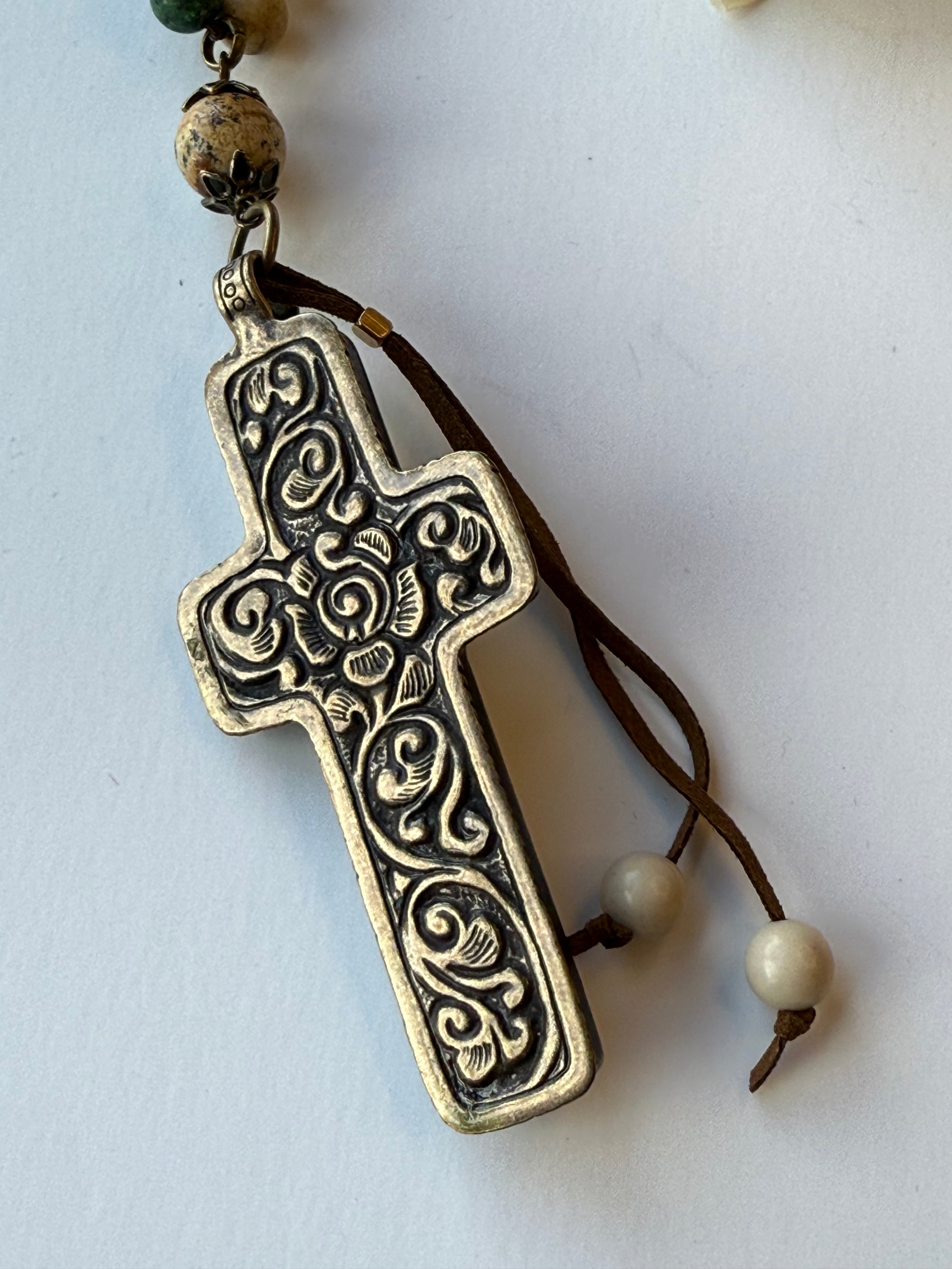 Decorative cross pendant with beads on a white background