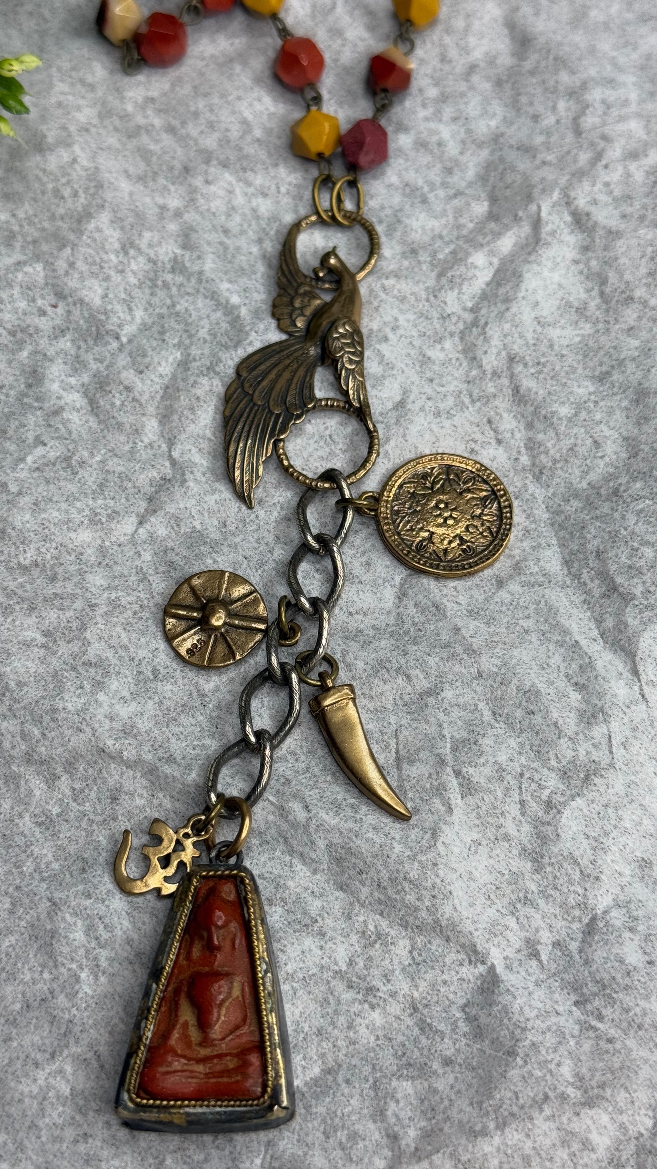 Necklace with various charms on a textured gray surface