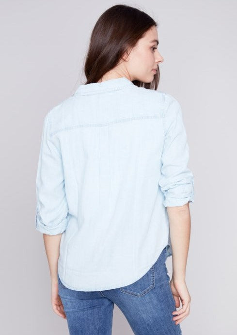 back view of model wearing long sleeve Tencel shirt in a very light colored denim.