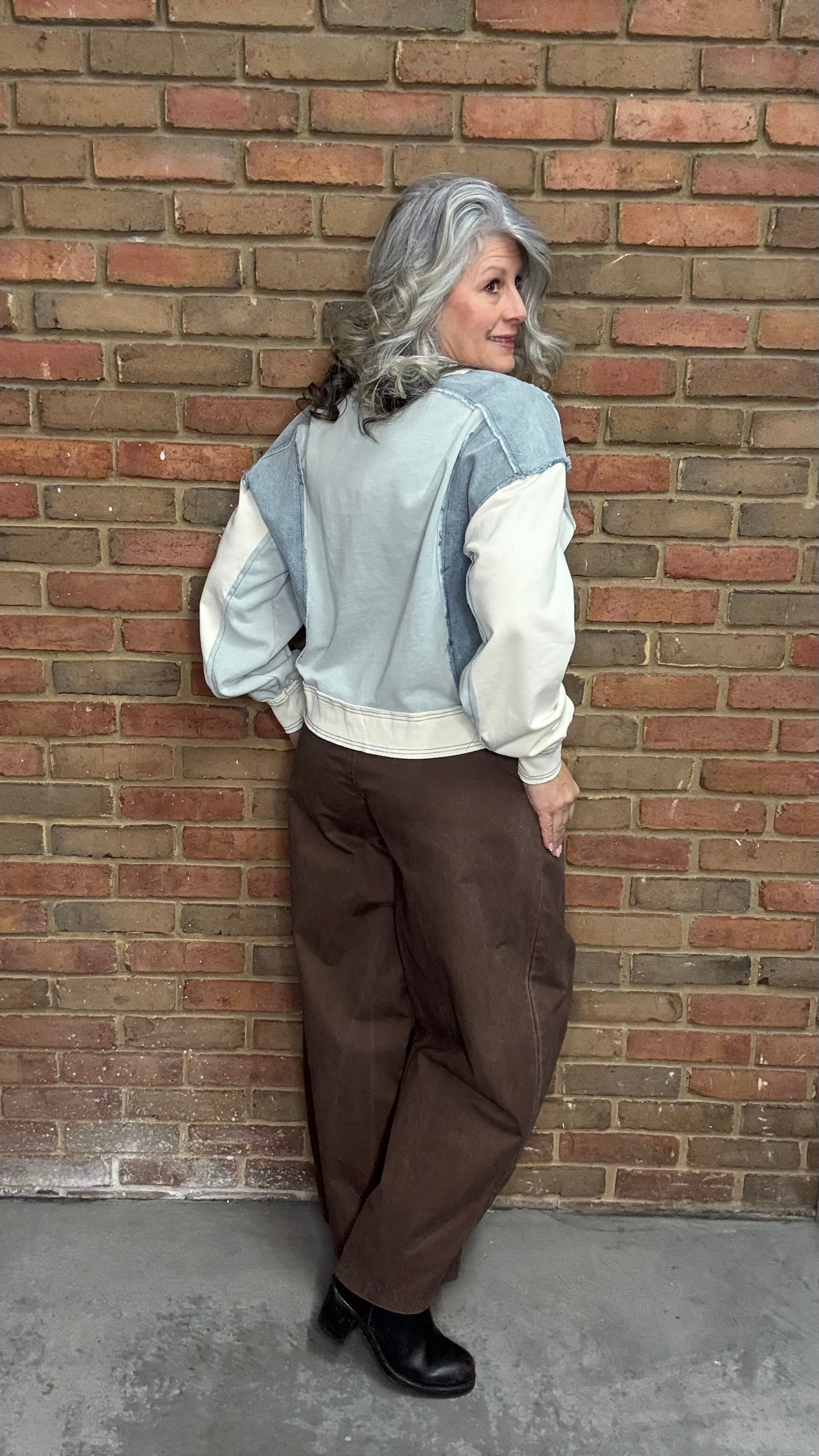 Person wearing the blue Color Block Pull on with the Brown Pull On Barrel Pants, standing against a brick wall.