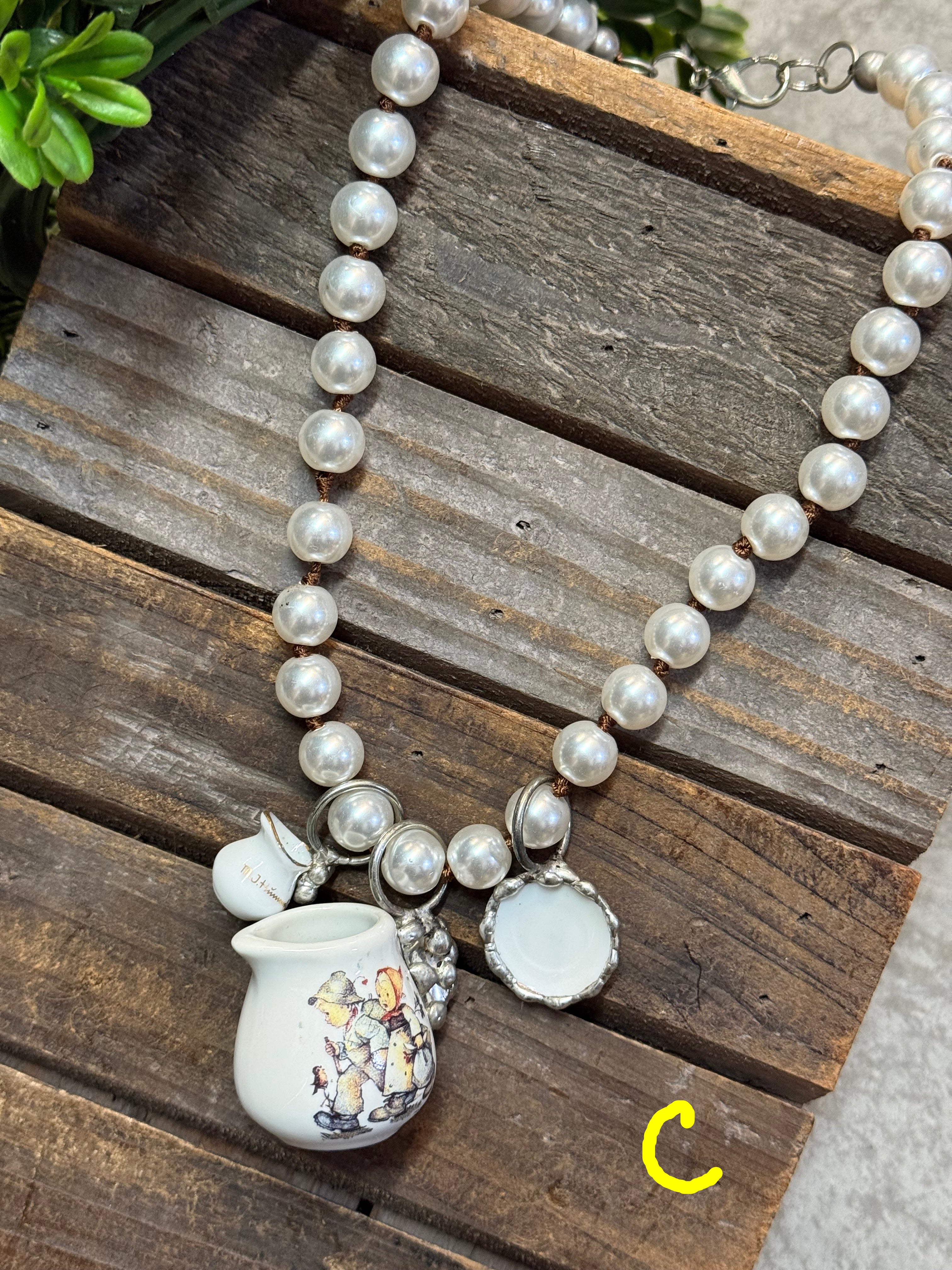 Pearl necklace with a decorative pendant on a wooden surface
