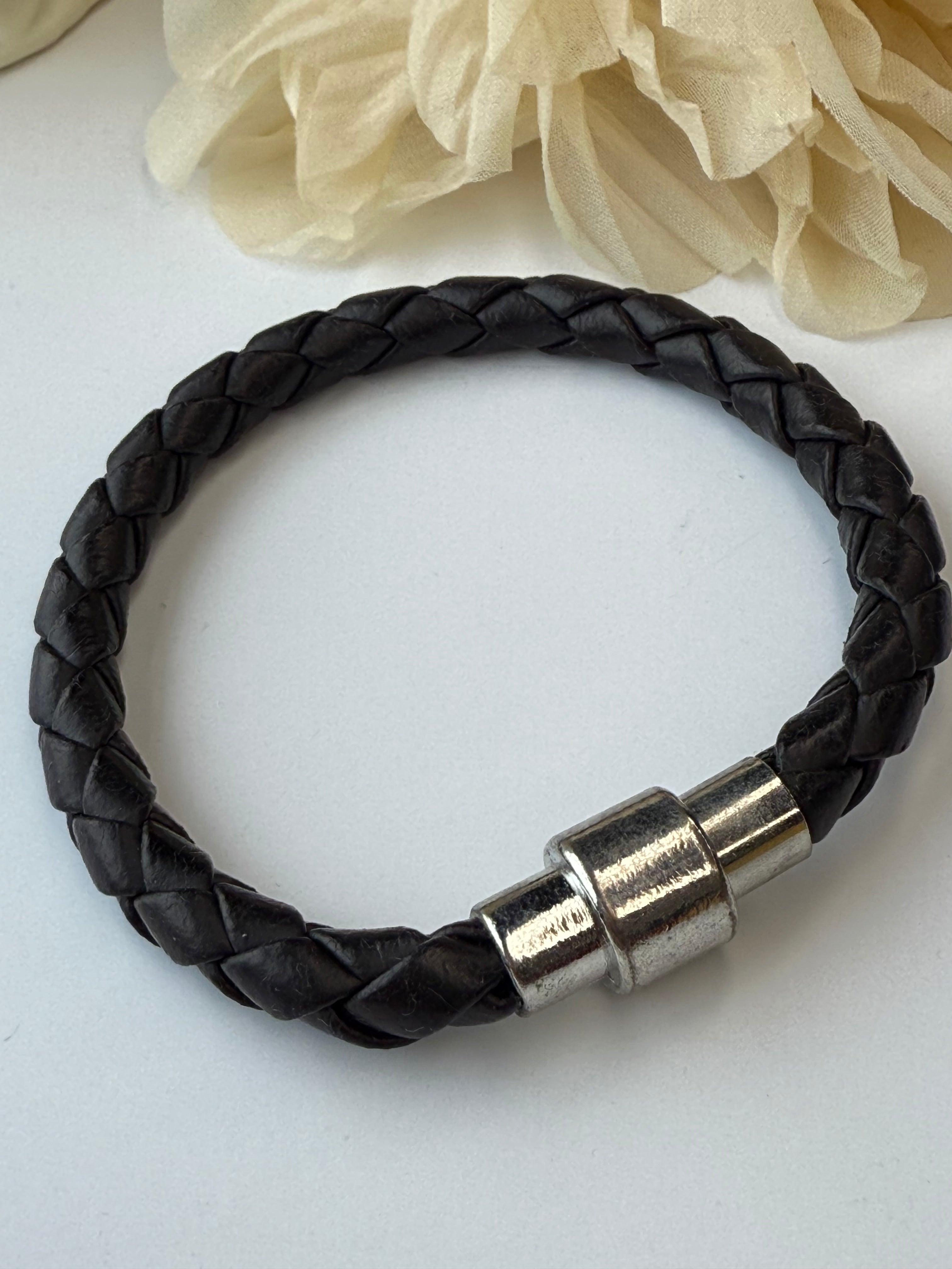 Black braided leather bracelet with a silver clasp on a white background