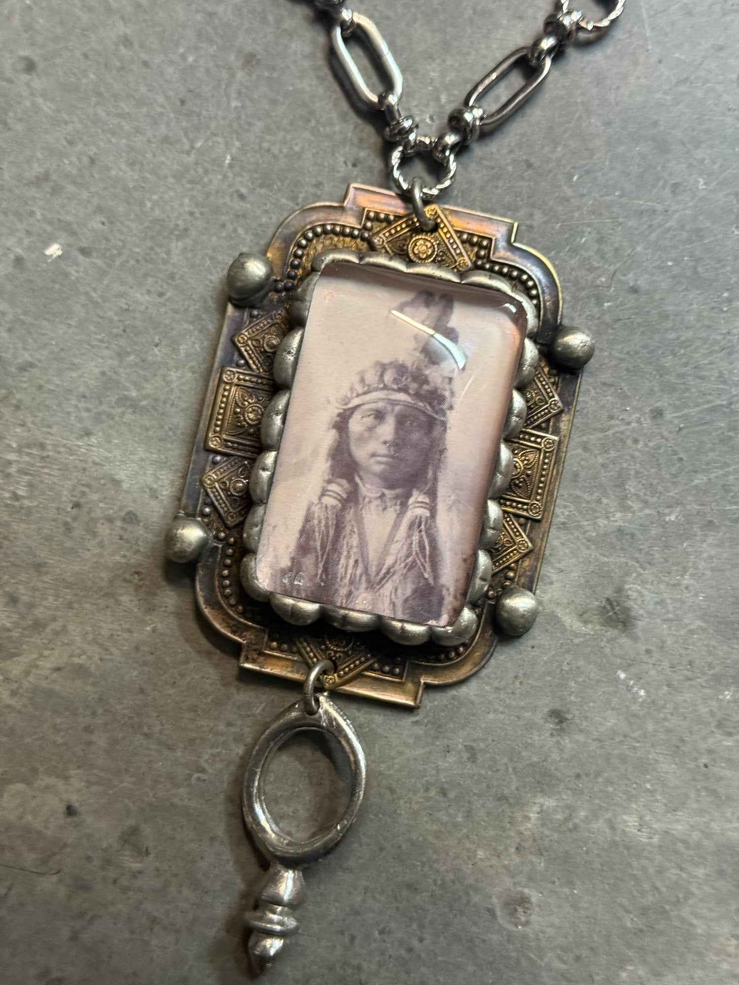 Vintage-style necklace with a photo frame pendant on a textured surface