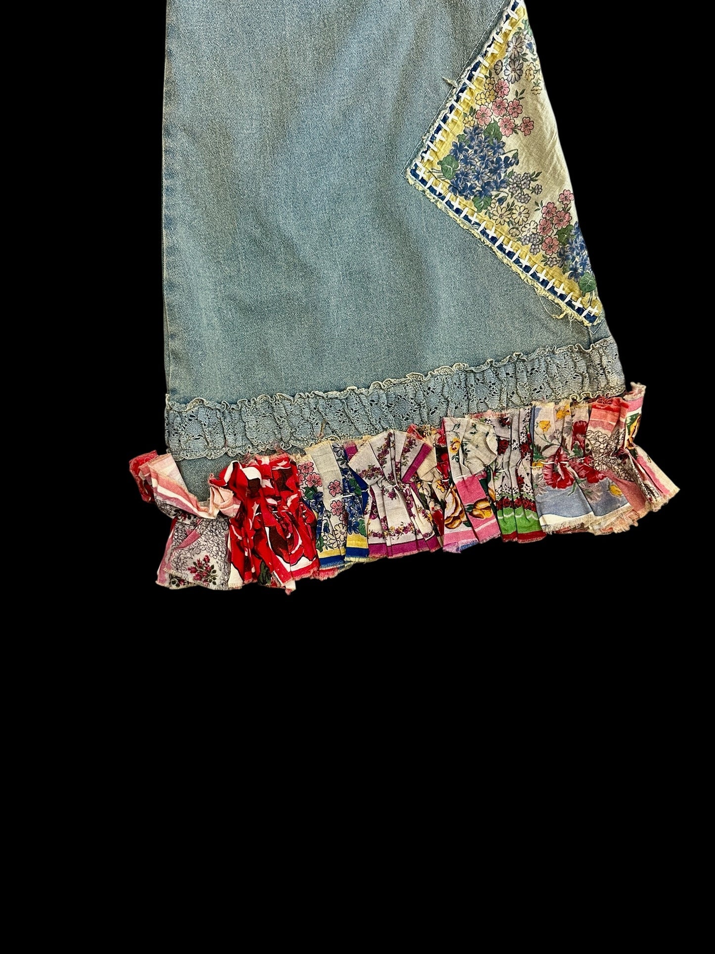 Denim pant with colorful ruffled hem on a black background