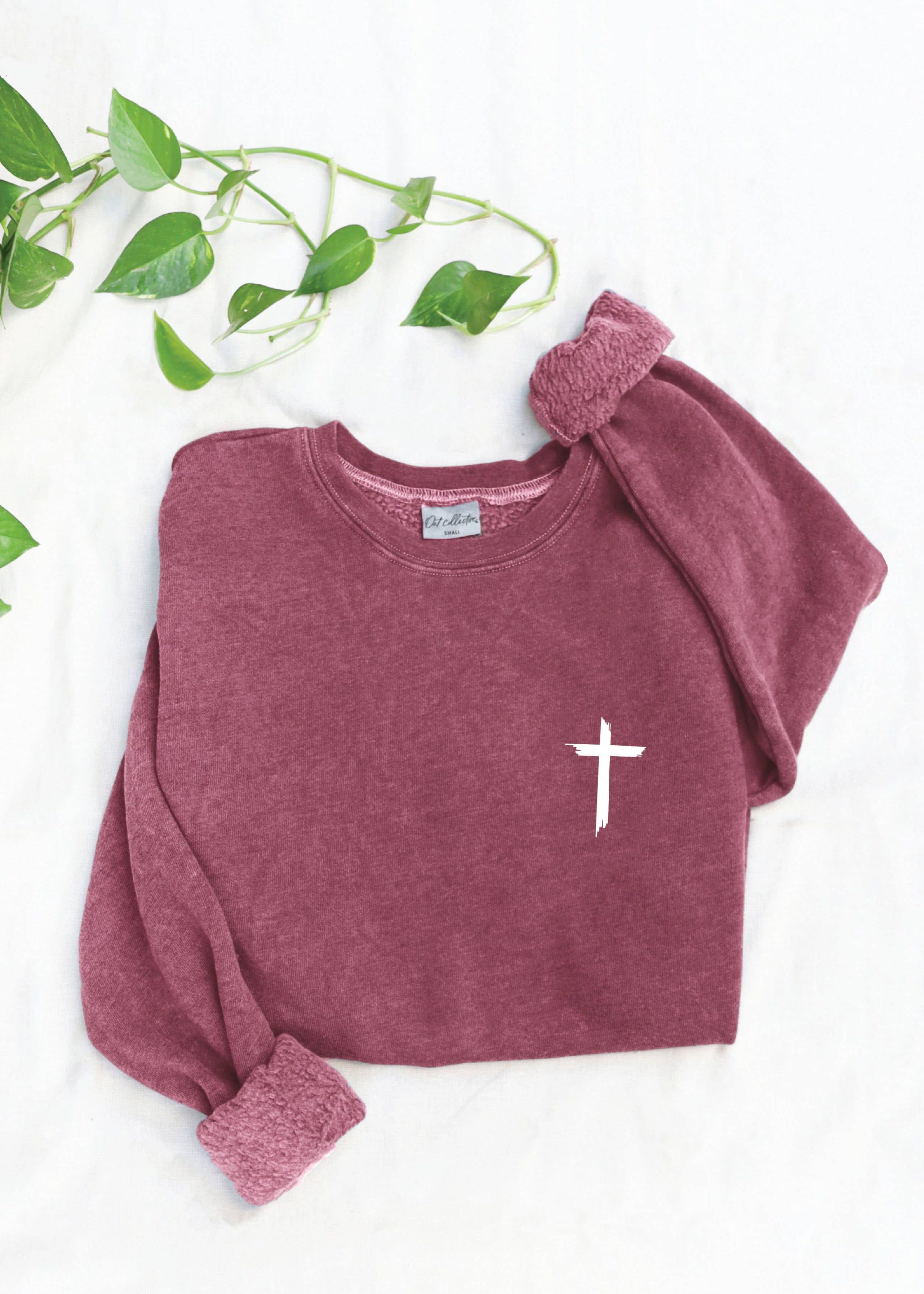 Maroon sweatshirt with a white cross design on a white background