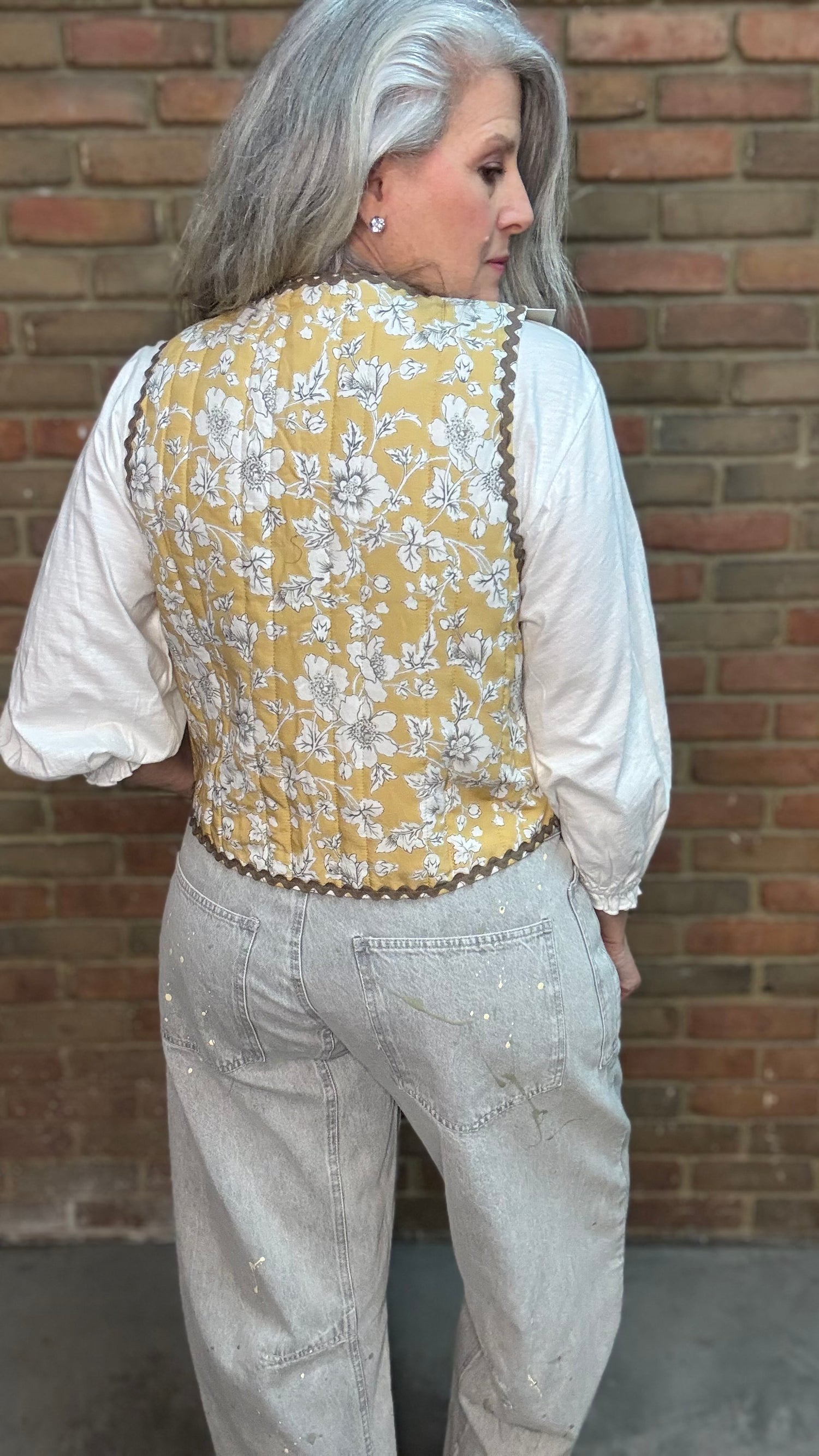 Woman wearing Quilted Tie Front Vest - Honey Bloom over Basic Long Sleeve Crew Neck Top paired with Oyster Grey Big Pocket Jeans.