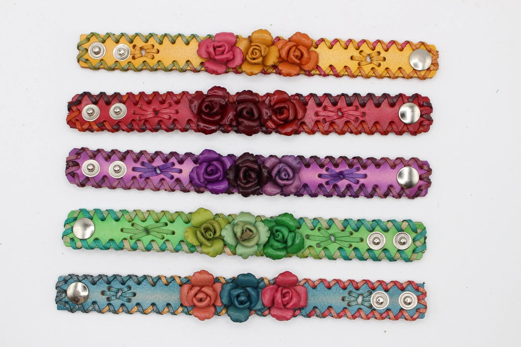 A collection of leather bracelets with triple rose designs in various colors, featuring metallic accents and leather strap with stitching.