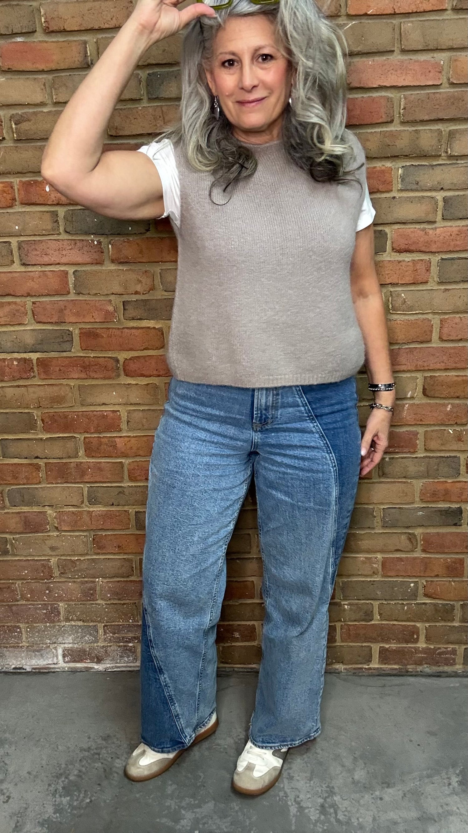 Woman in the HOLLY Super High Rise Two Tone Straight Jean casual outfit standing against a brick wall