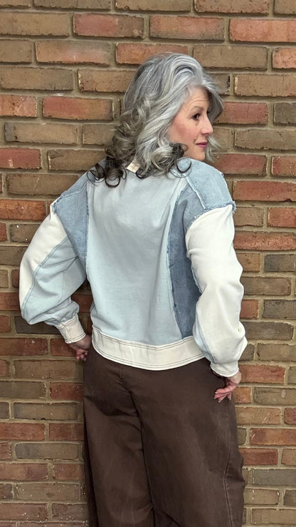 Person wearing the Color Block Pullover Top and the brown pullon barrel pants standing against a brick wall.