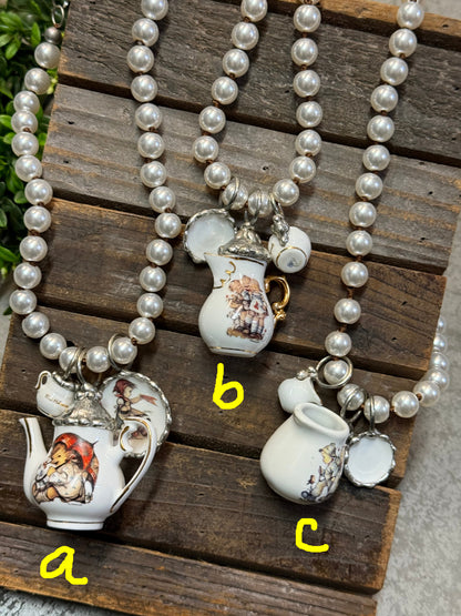 Pearl necklace with teacup pendants on a wooden surface