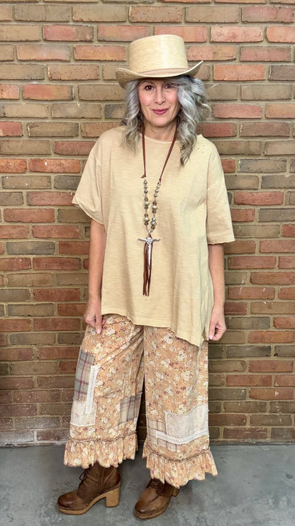 Woman wearing a beige sleeveless top with a Hammered Cross Necklace against a brick wall.