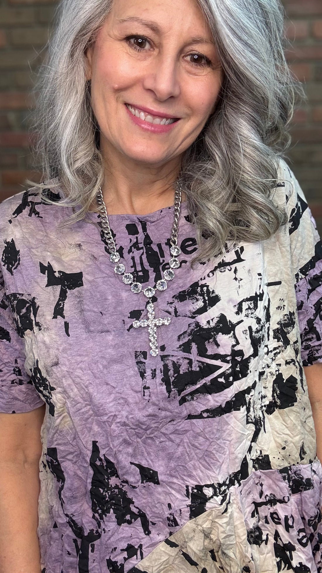Woman wearing Matilda Top - Aura with a brick wall background