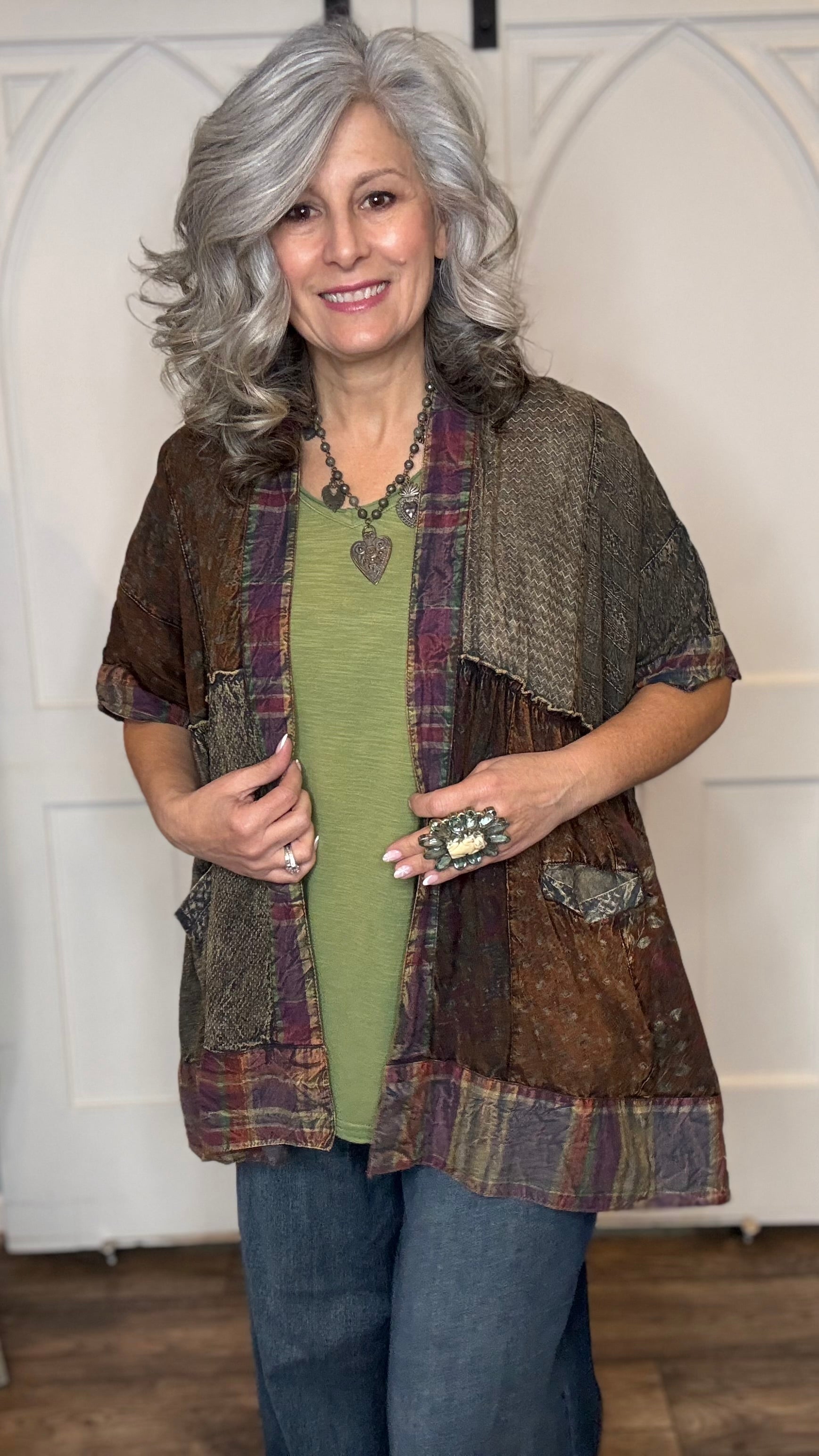 Woman wearing Boho Kimono Shrug Cardigan over a Moon Dance V-Neck in Olive and Judy Blue Palazzo Patch Pocket jeans in front of a white door.