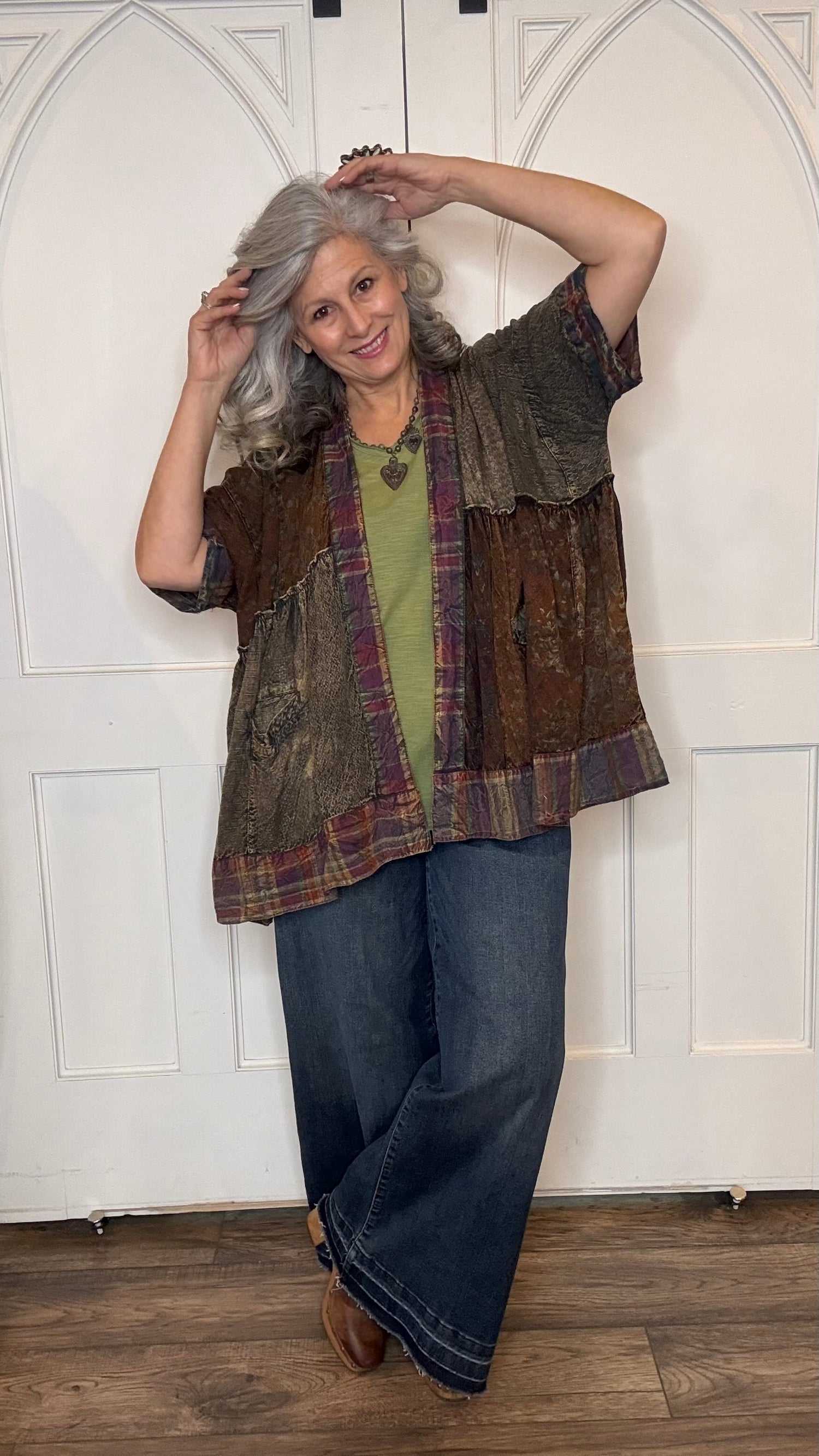 Woman wearing Boho Kimono Shrug Cardigan over a Moon Dance V-Neck in Olive and Judy Blue Palazzo Patch Pocket jeans in front of a white door.