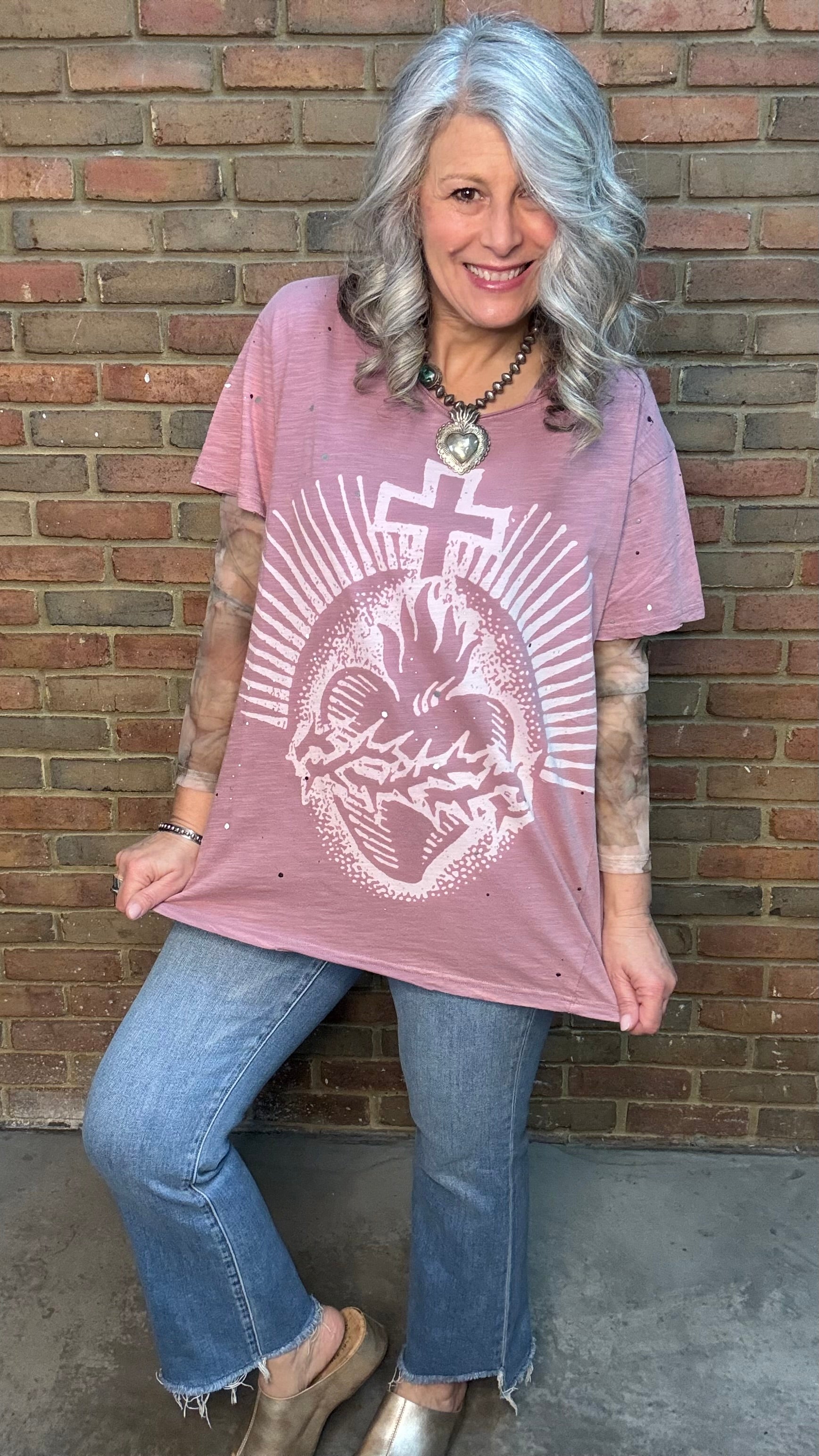 Woman wearing Moon Dance Tee - Cherished Heart tee against brick wall.