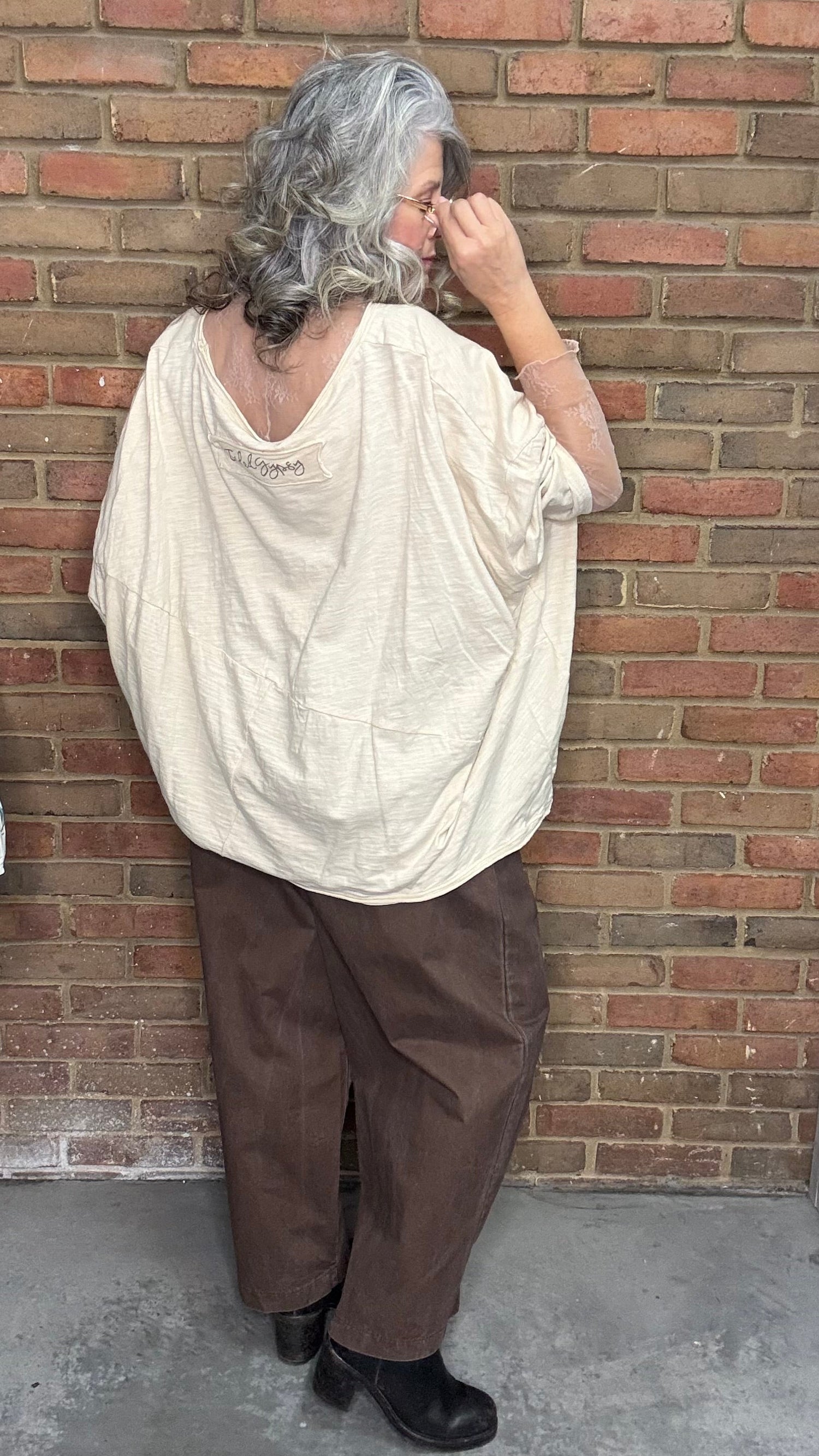 Person wearing Be Free Top - Growth and the Brown Pull On Barrel pants standing against a brick wall.