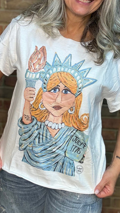 Person wearing a t-shirt with a graphic design in front of a brick wall