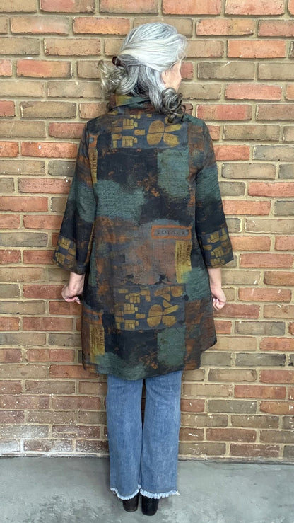 Woman wearing Blythe Tawn Tunic and  the Front Tulip Hem Bootcut Pant jeans standing against a brick wall.