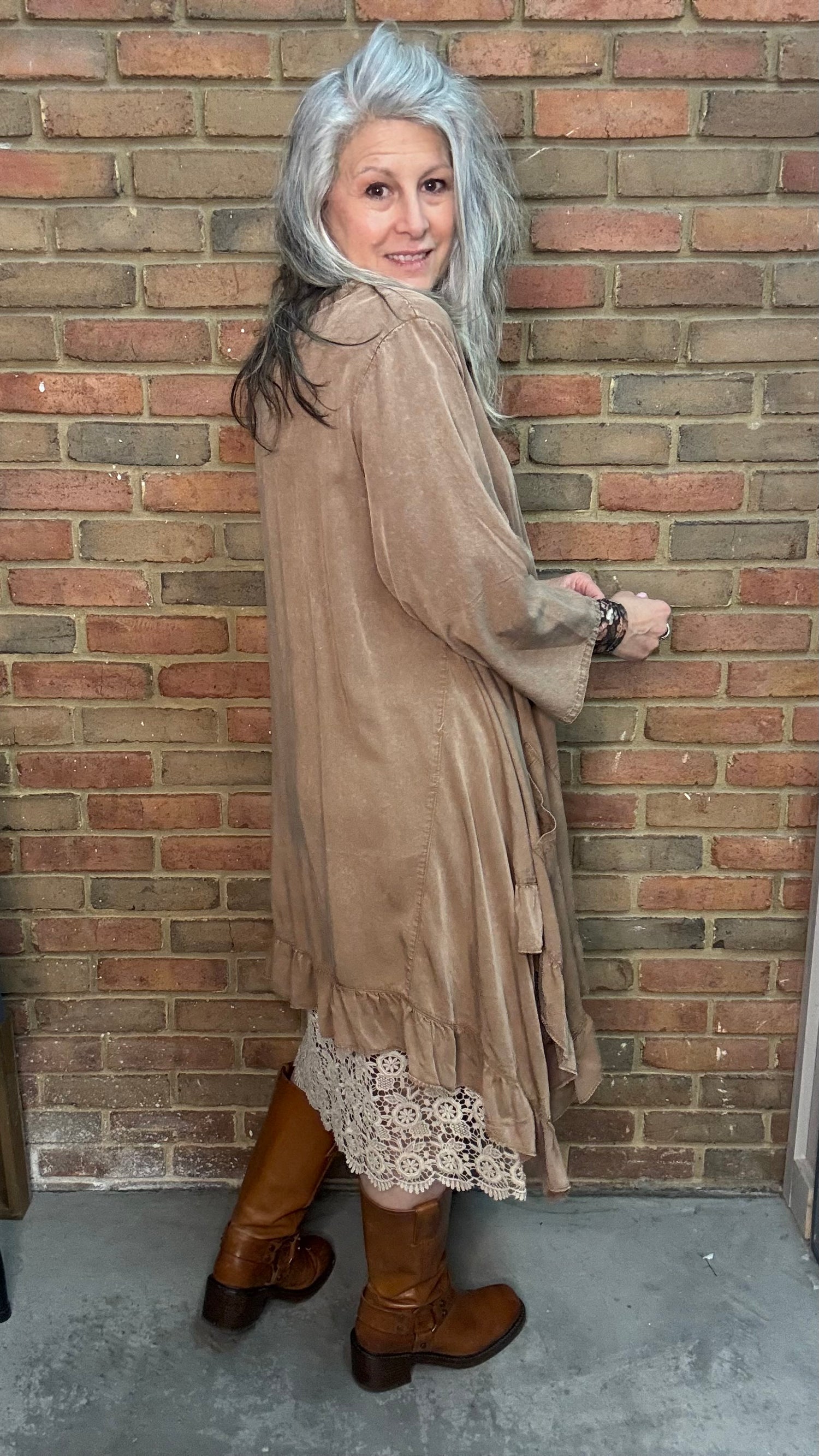 Woman wearing Tan Round Neck Ruffle Top/dress with a mesh top, slip, and Frye Boots.