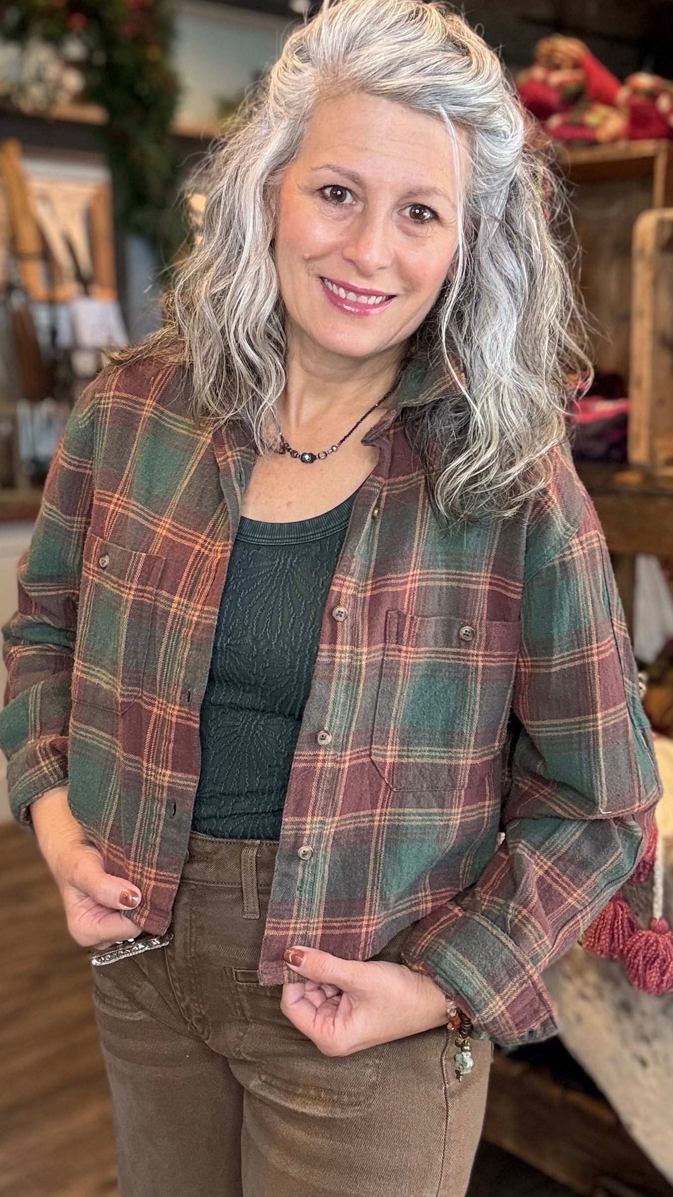 Person wearing a green plaid crop shirt jacket in a store setting