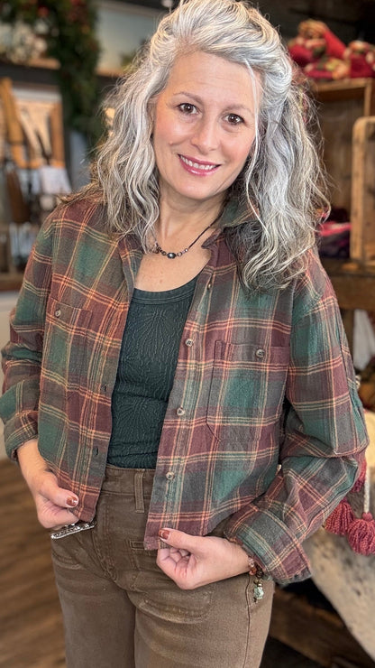 Person wearing a green plaid crop shirt jacket in a store setting