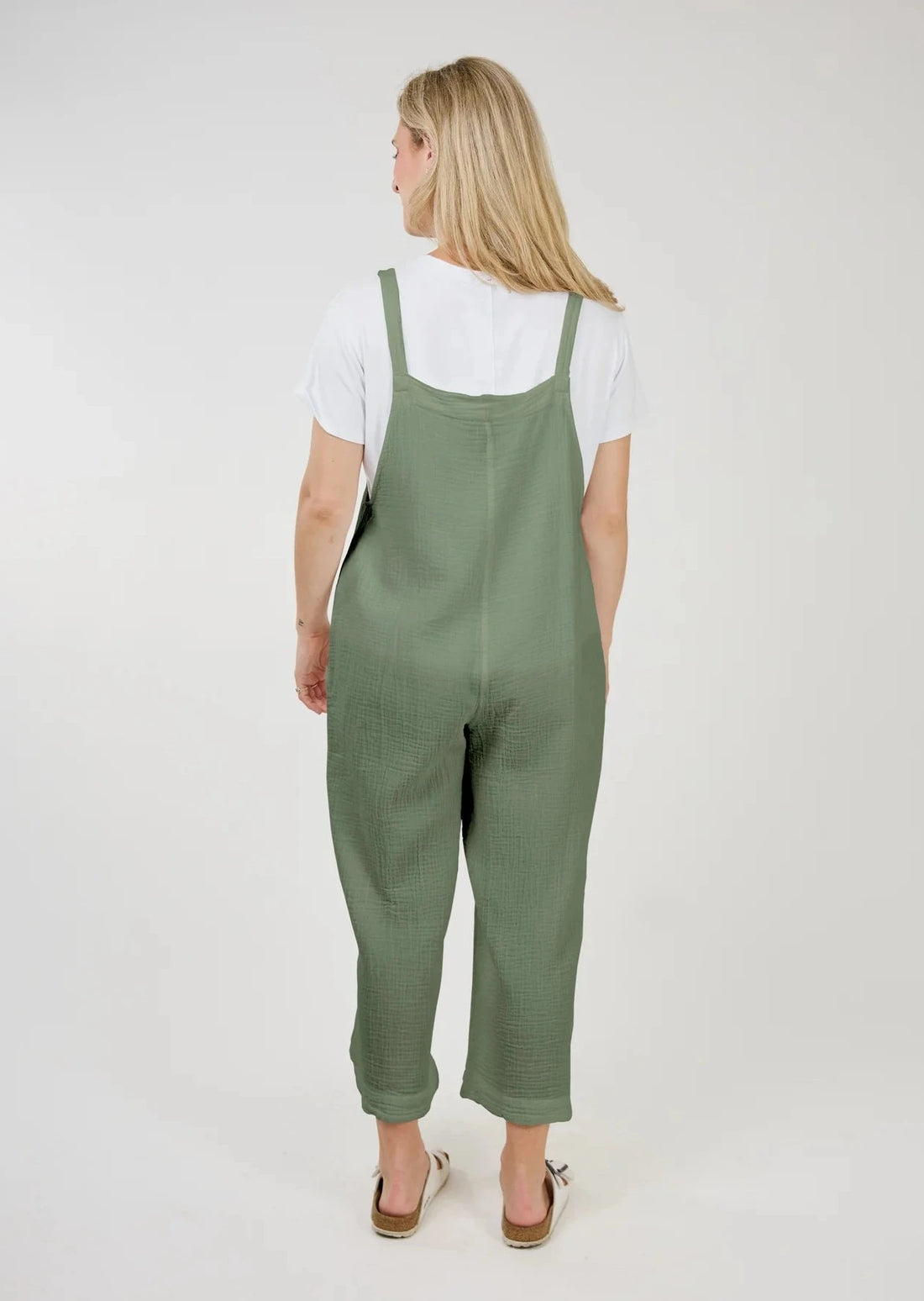 Back view of model wearing Grace Cotton Gauze Overalls with a white tee shirt underneath.