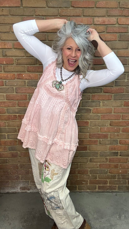 Woman wearing Eyelet Lace Tank over a white shirt, standing against a brick wall.