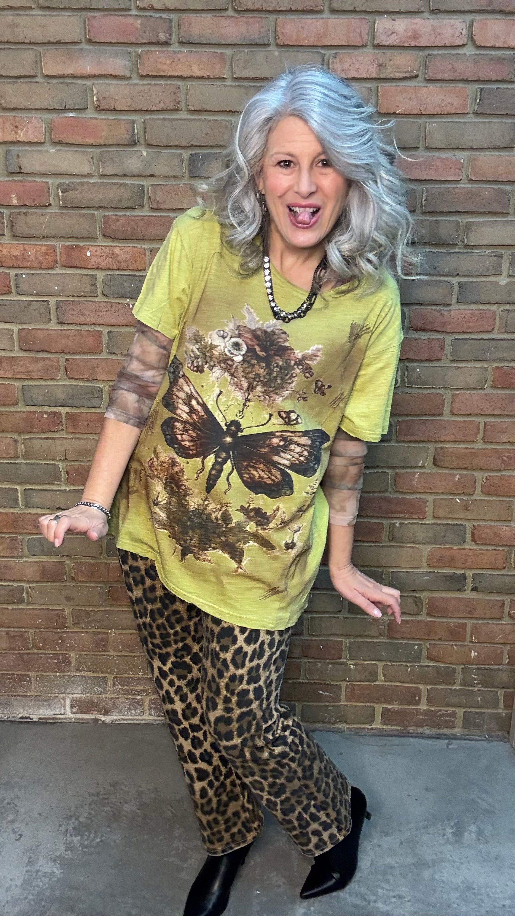 Woman wearing Moon Dance Tee - Evening Stop in front of a brick wall.