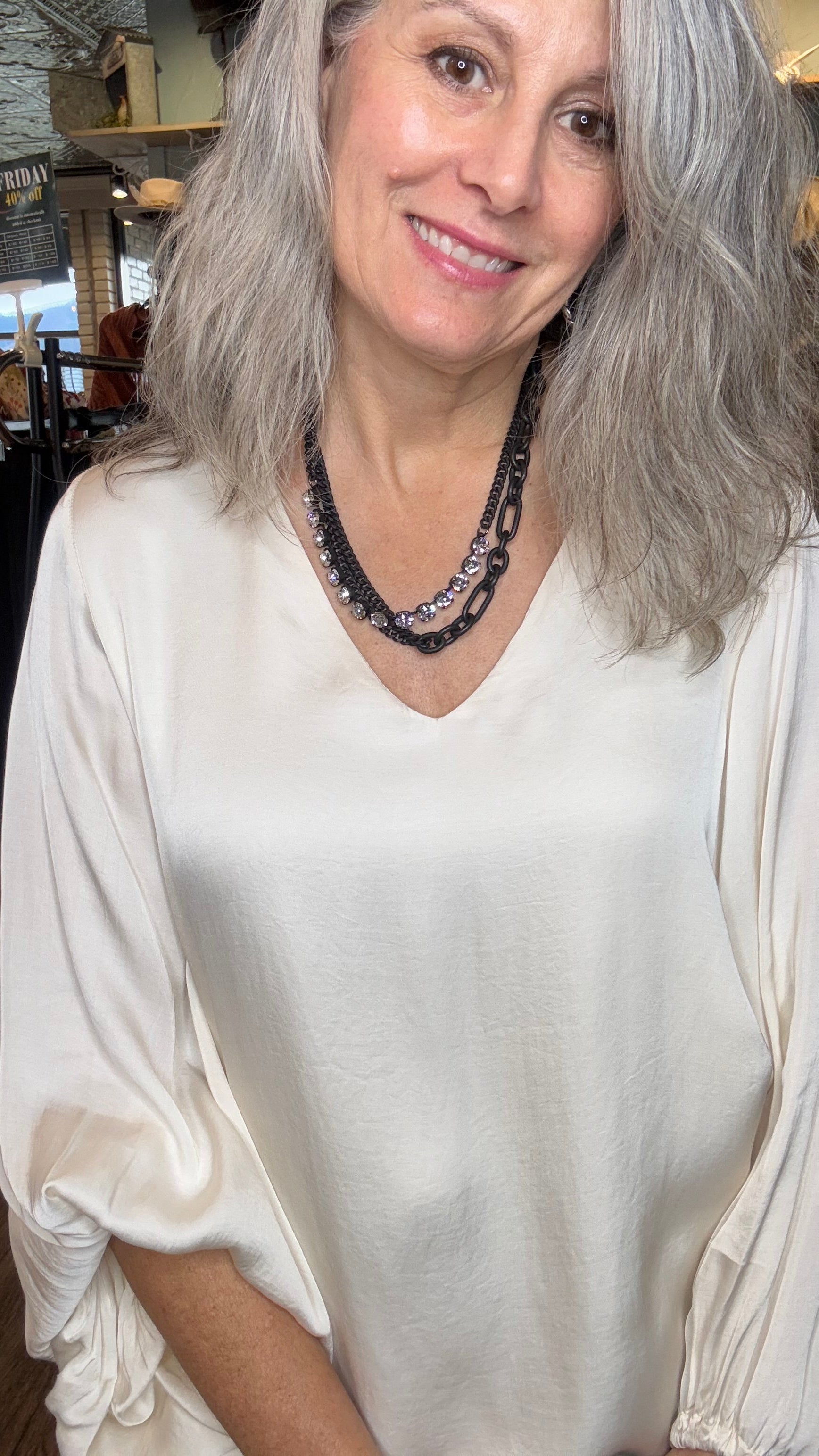 Woman wearing a white top with a blurred indoor background