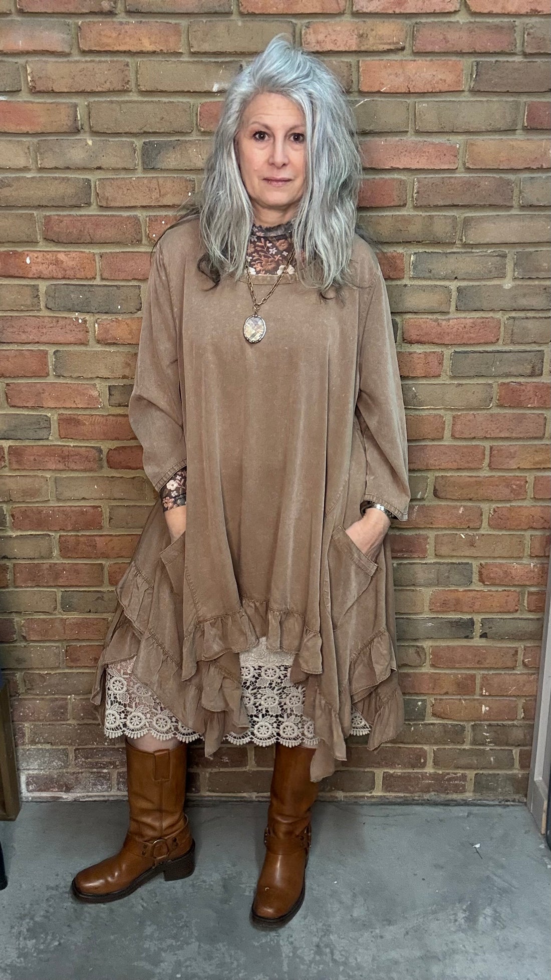 Woman wearing Tan Round Neck Ruffle Top/dress with a mesh top, slip, and Frye Boots.