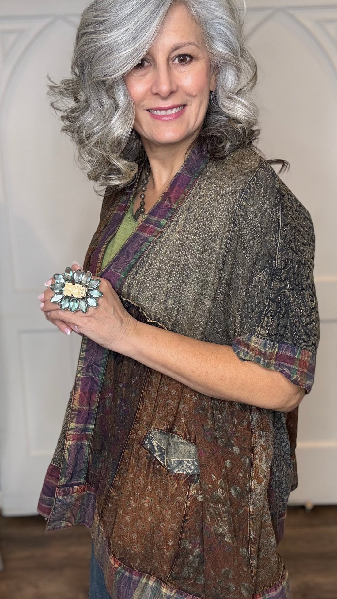 Woman wearing Boho Kimono Shrug Cardigan over a Moon Dance V-Neck in Olive and Judy Blue Palazzo Patch Pocket jeans in front of a white door.