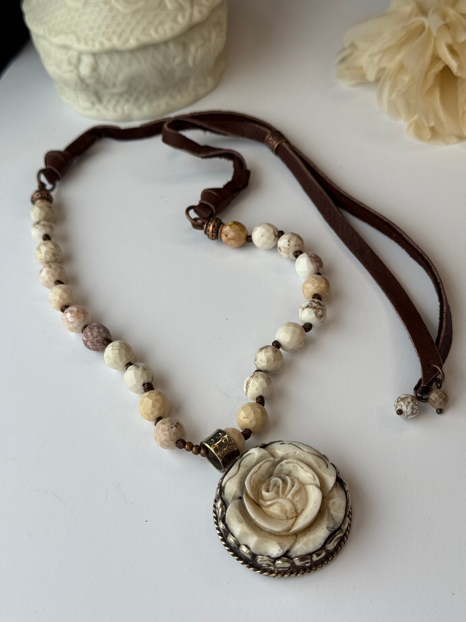 Necklace with rose-shaped pendant on a white surface