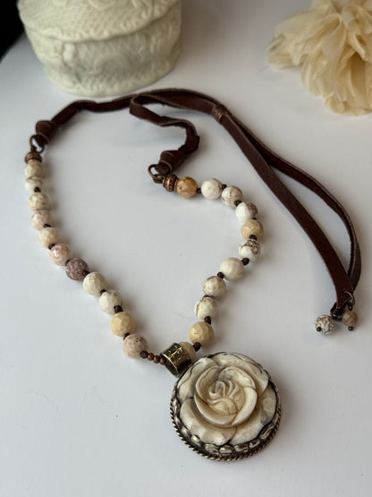 Necklace with rose-shaped pendant on a white surface