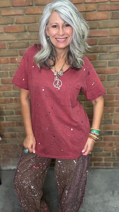 Woman in red shirt in front of brick wall.