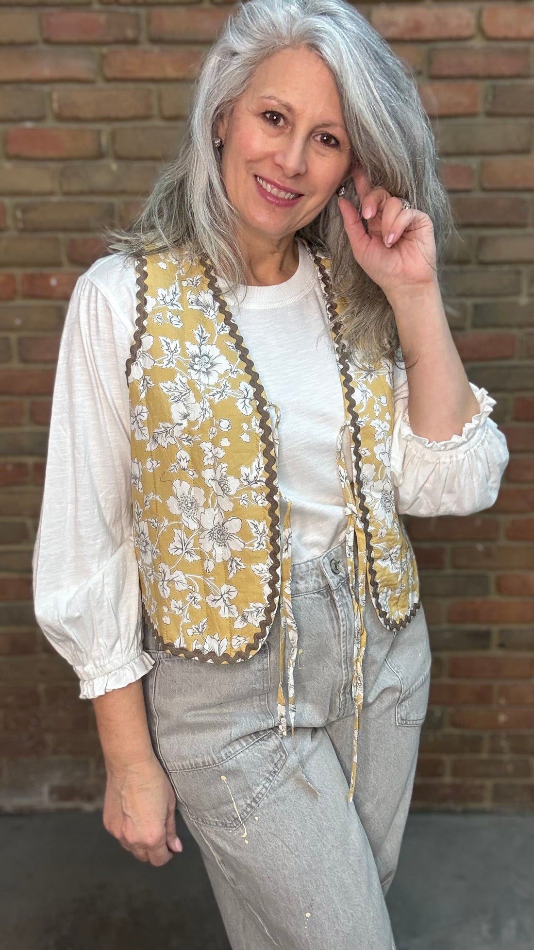 Woman wearing Quilted Tie Front Vest - Honey Bloom over Basic Long Sleeve Crew Neck Top paired with Oyster Grey Big Pocket Jeans