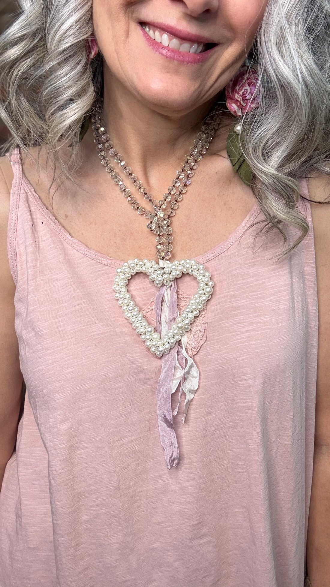 Woman wearing a Pearl Heart necklace with pink top.