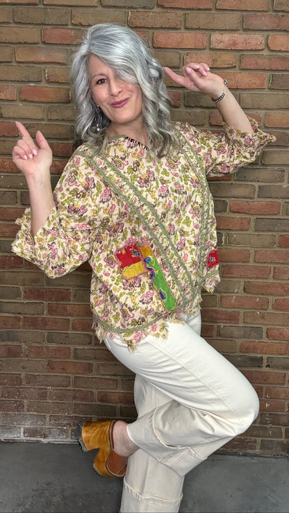 Woman wearing Desert Winds Top  against a brick wall.